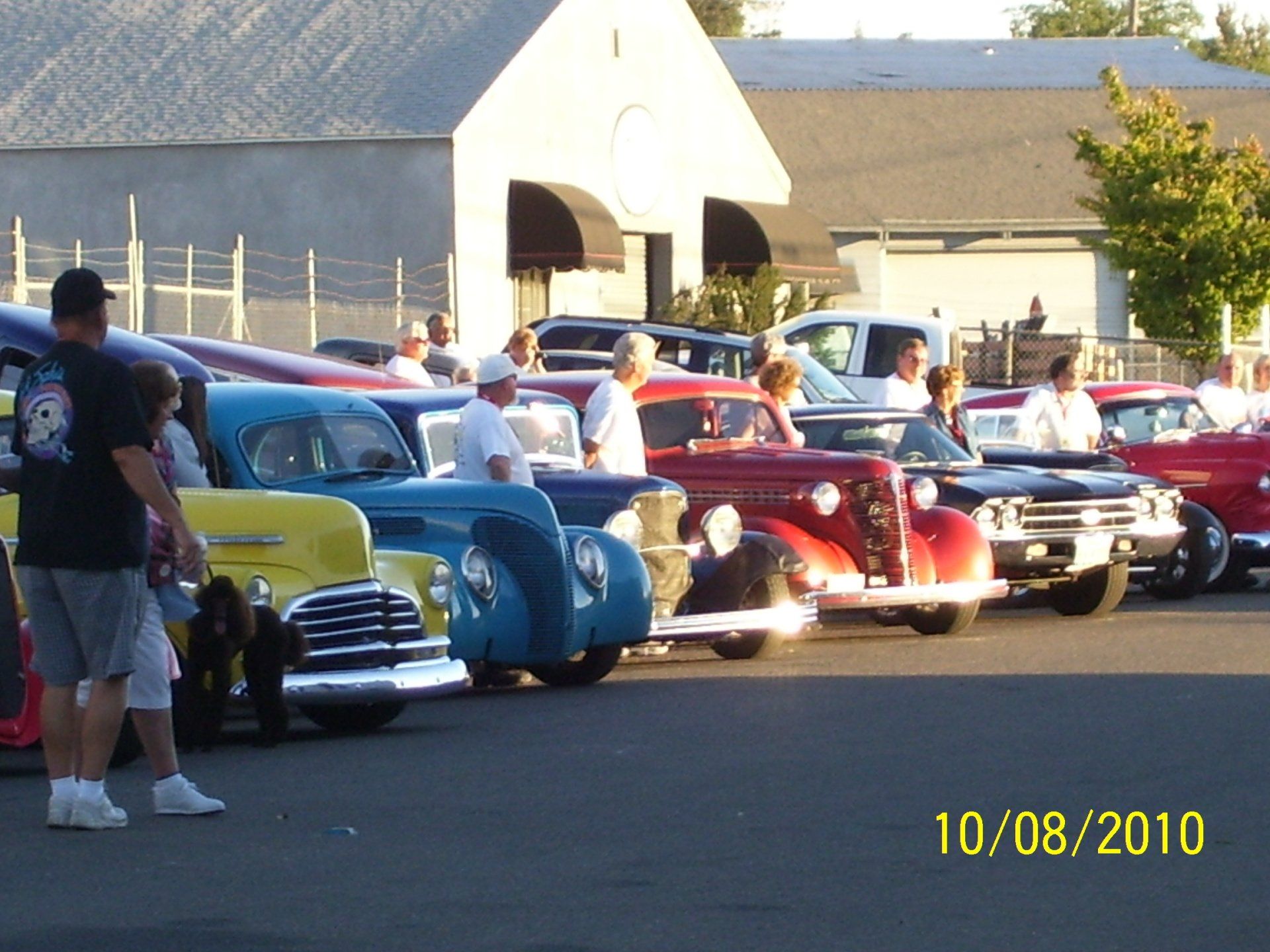 A row of cars are parked in a parking lot on 10/08/2010