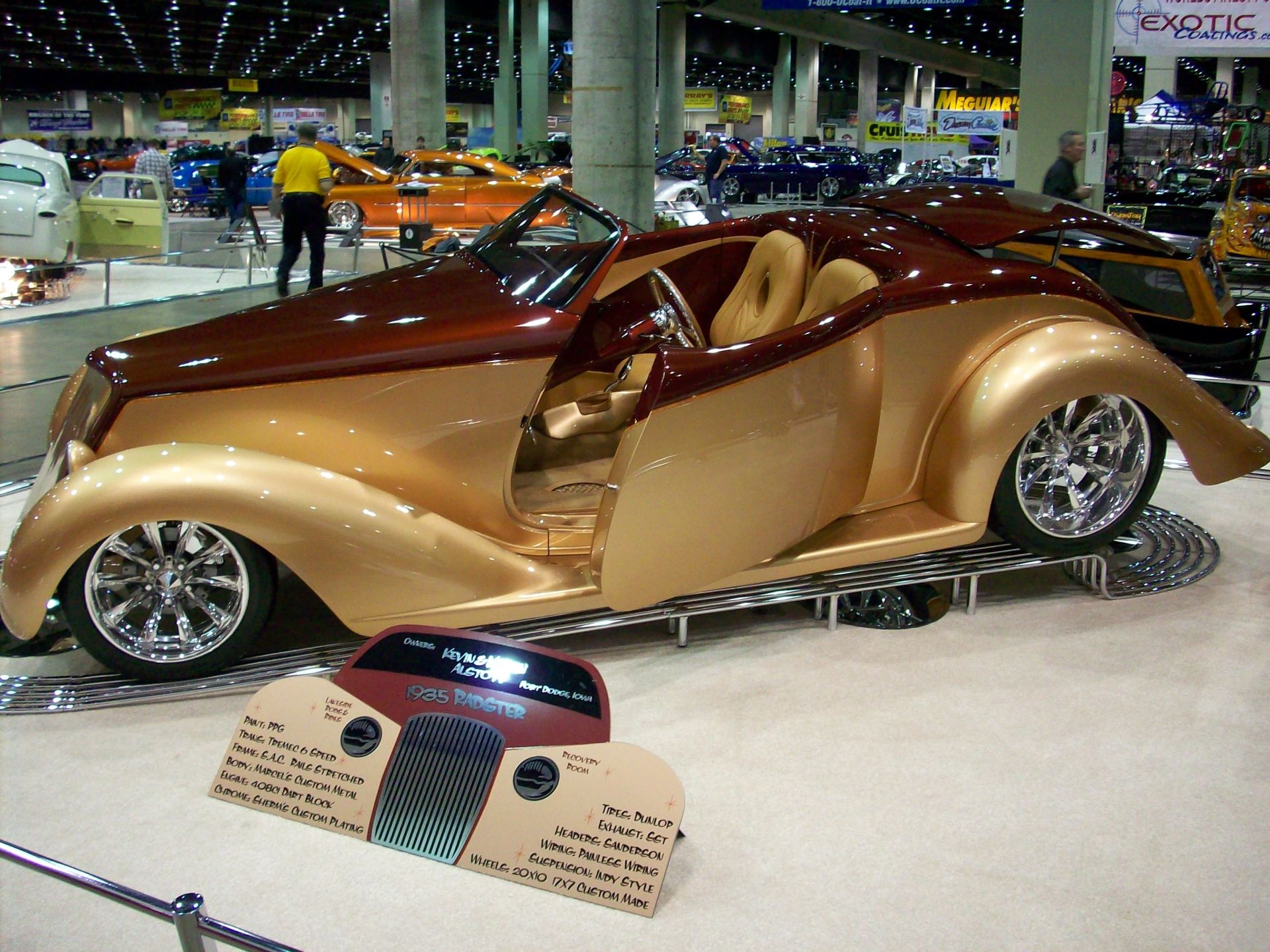 A car with the door open is on display at a car show