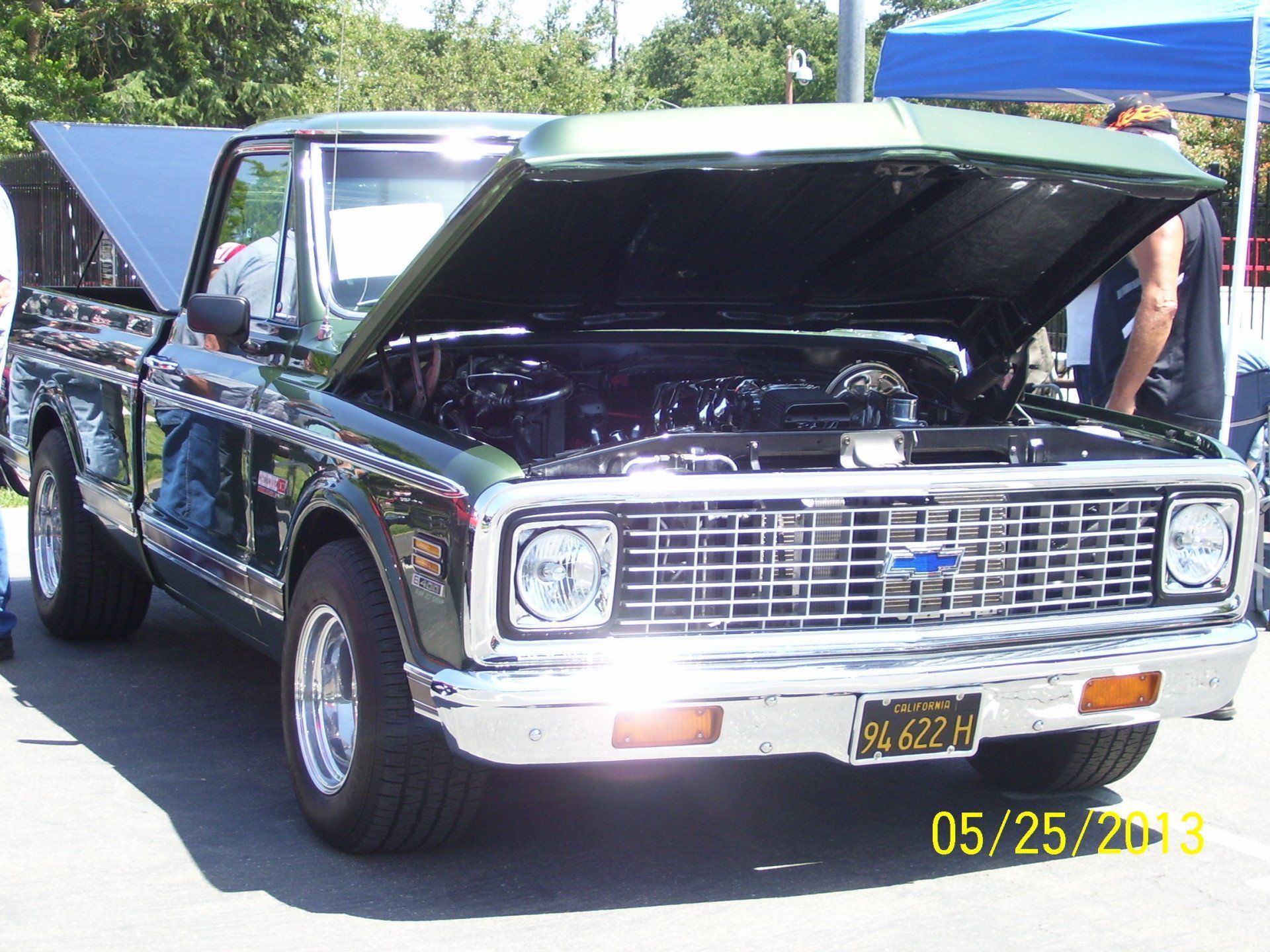 A green chevrolet truck with the hood open