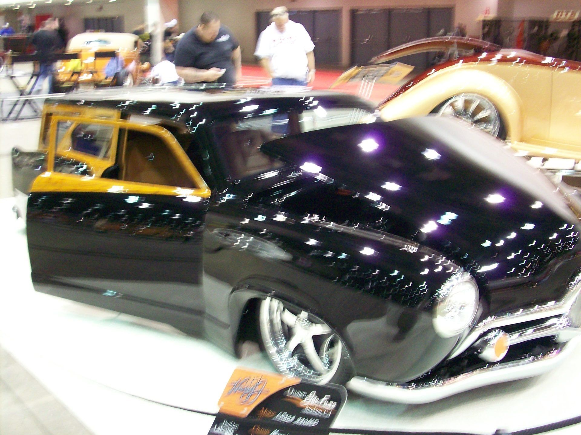 A black car is on display at a car show