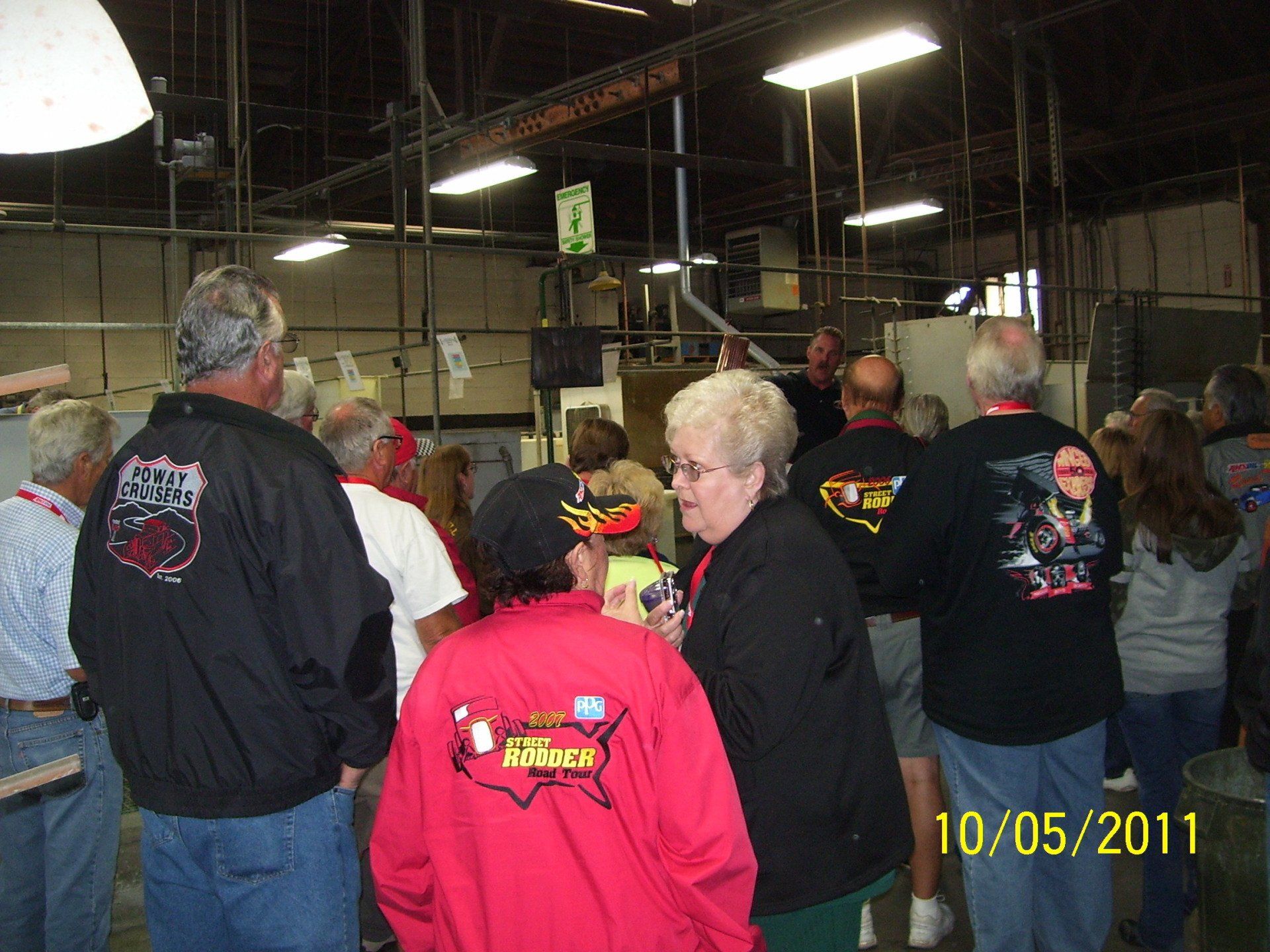 A group of people standing in a room with a photo taken on 10/05/11