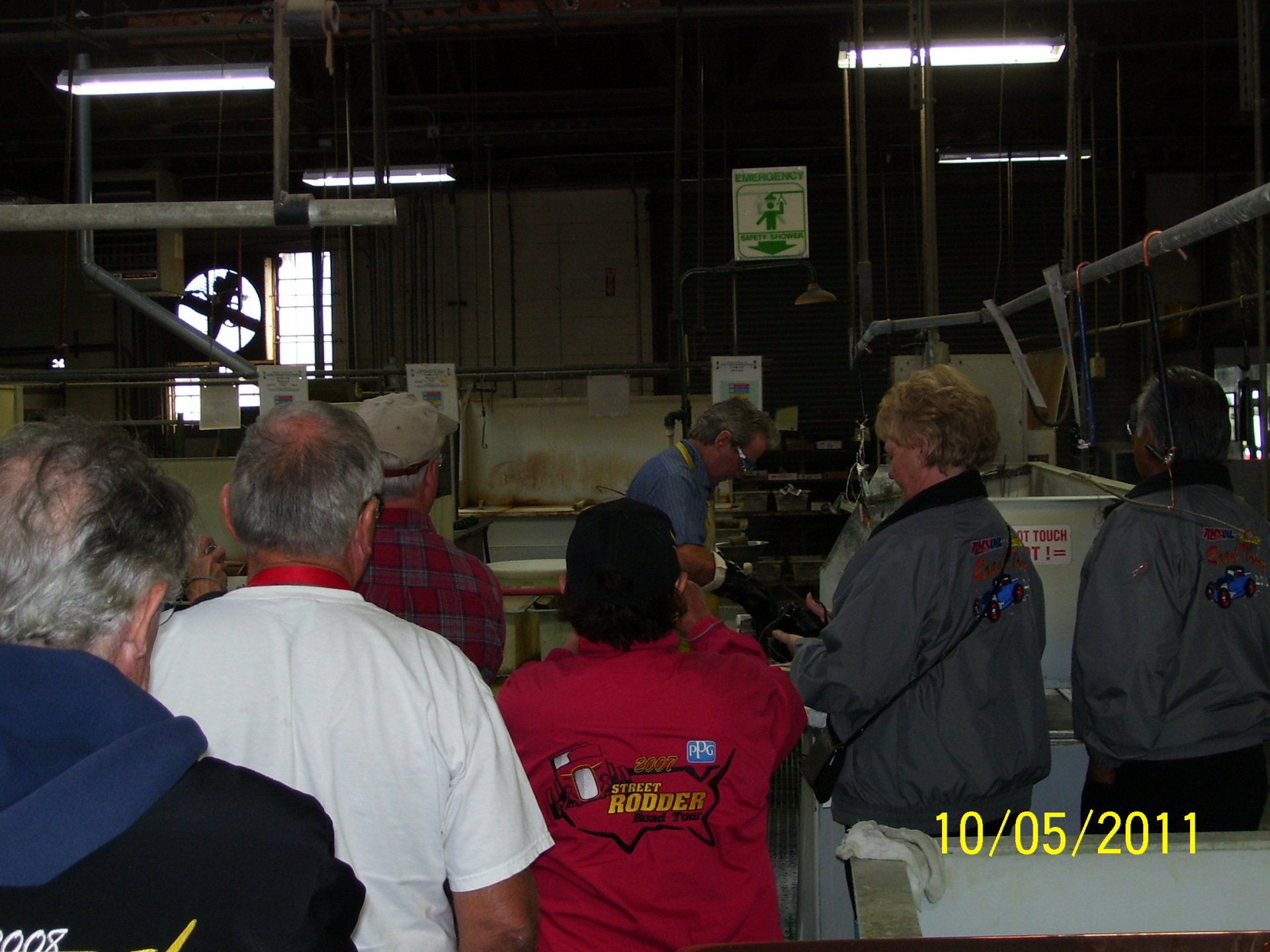 A group of people are standing in a room with the date 10/05/11