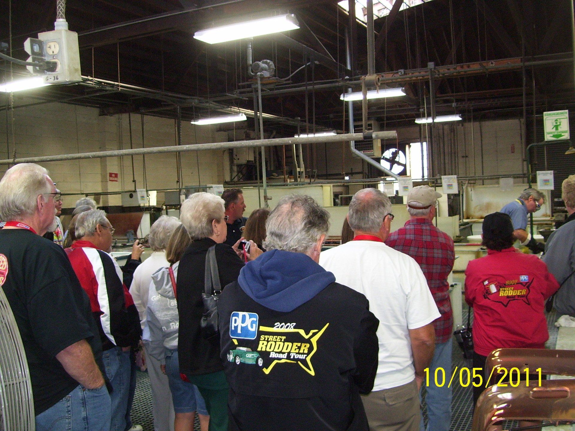 A group of people are standing in a room and one of them is wearing a shirt that says racing
