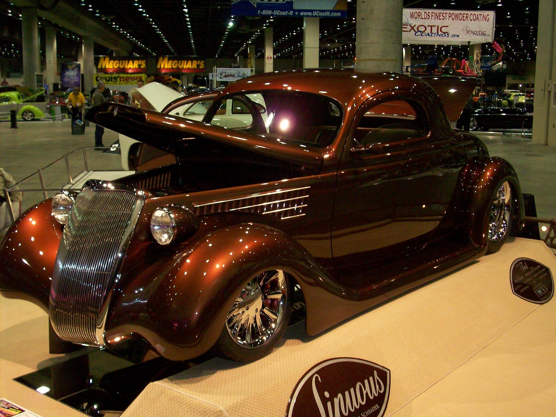 A car with the hood up is on display at a car show