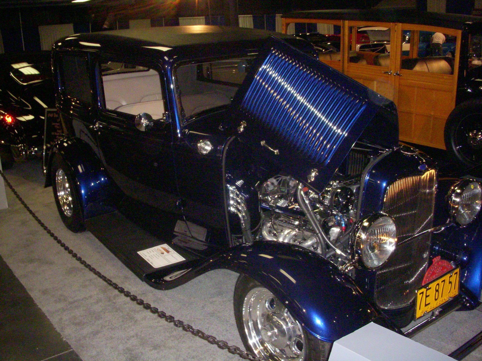 A blue car with the hood up has a license plate that says rs lkd