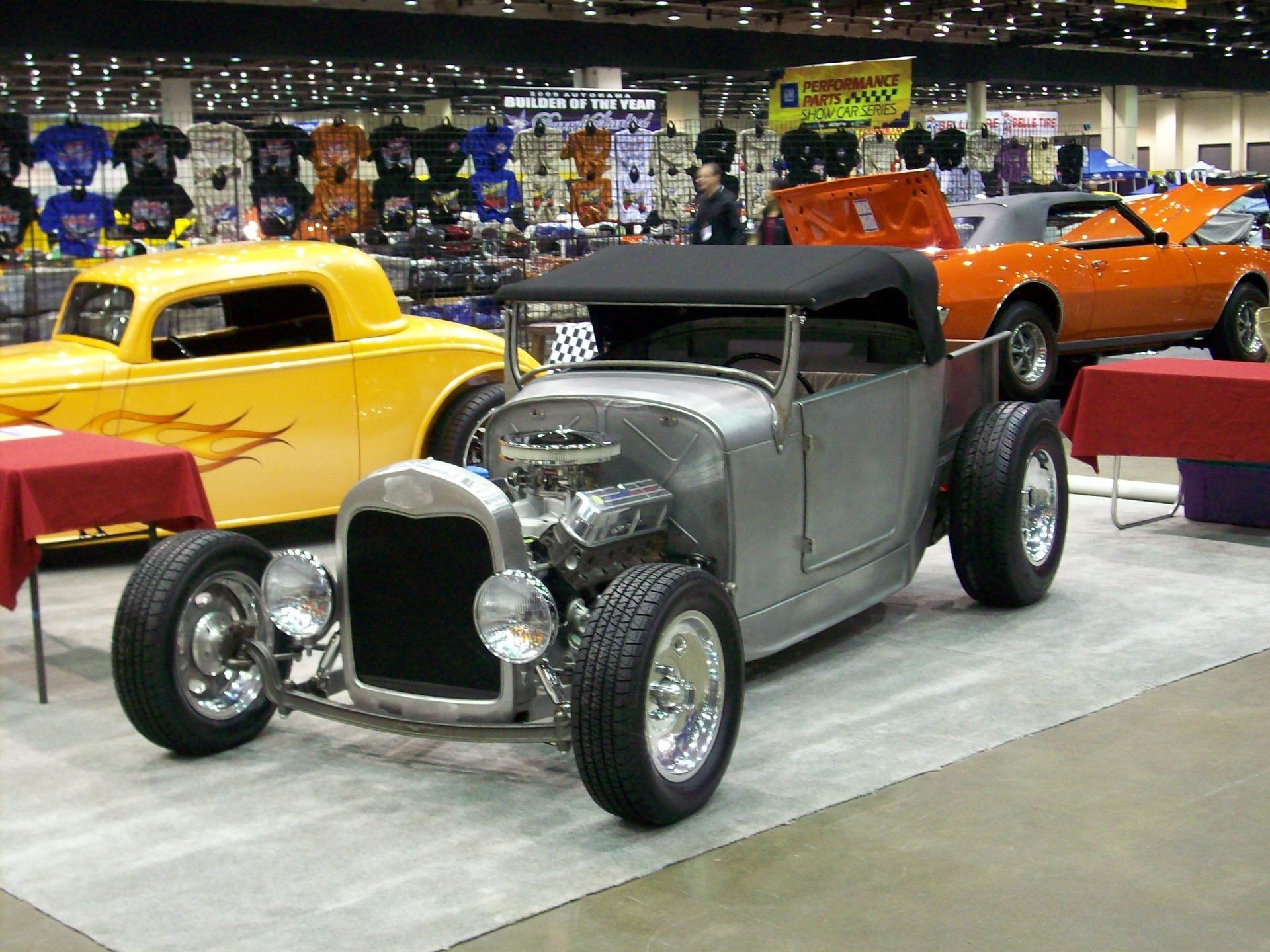 A yellow car is parked next to a silver car