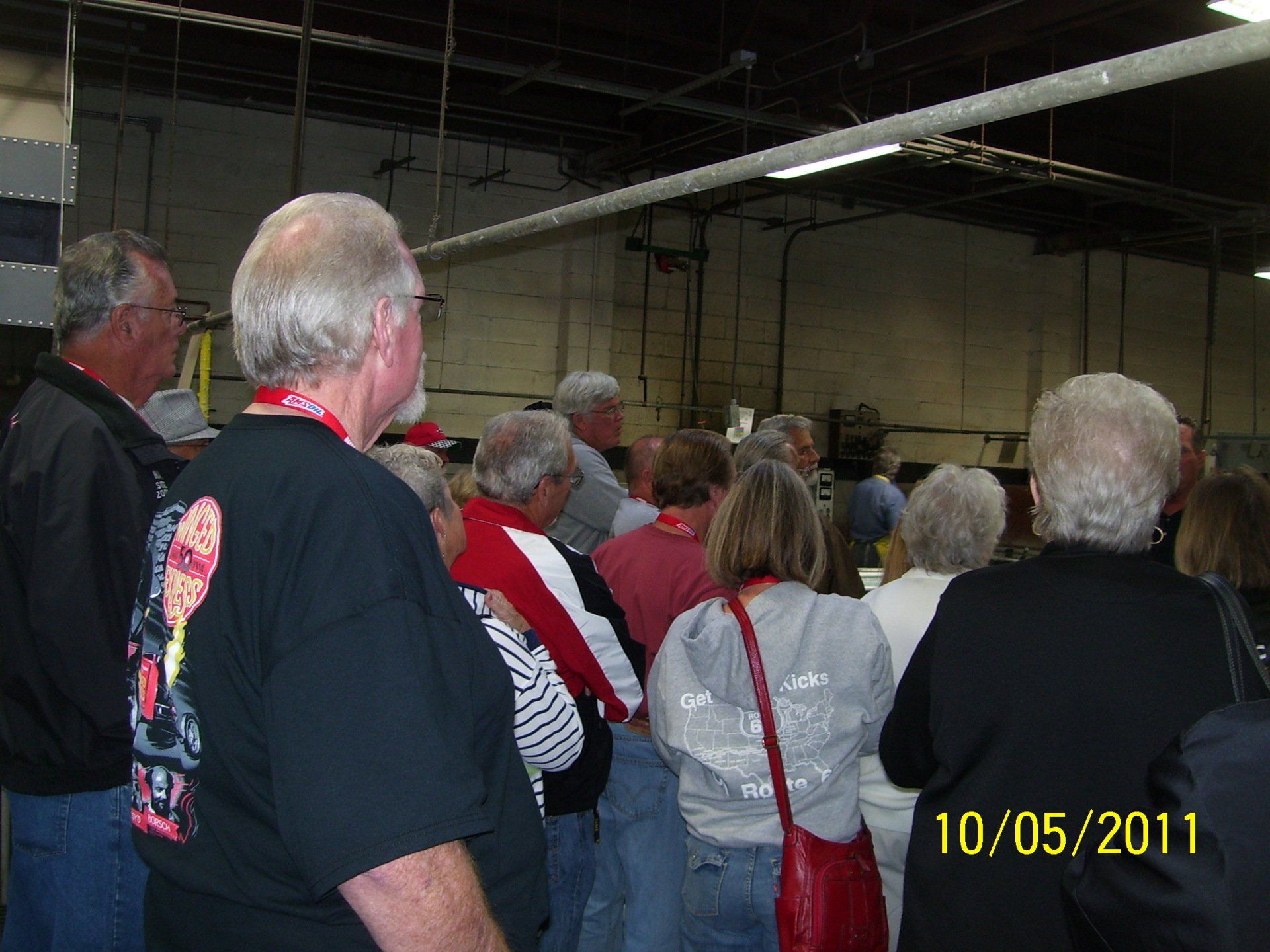 A group of people standing in a room with the date 10/05/11