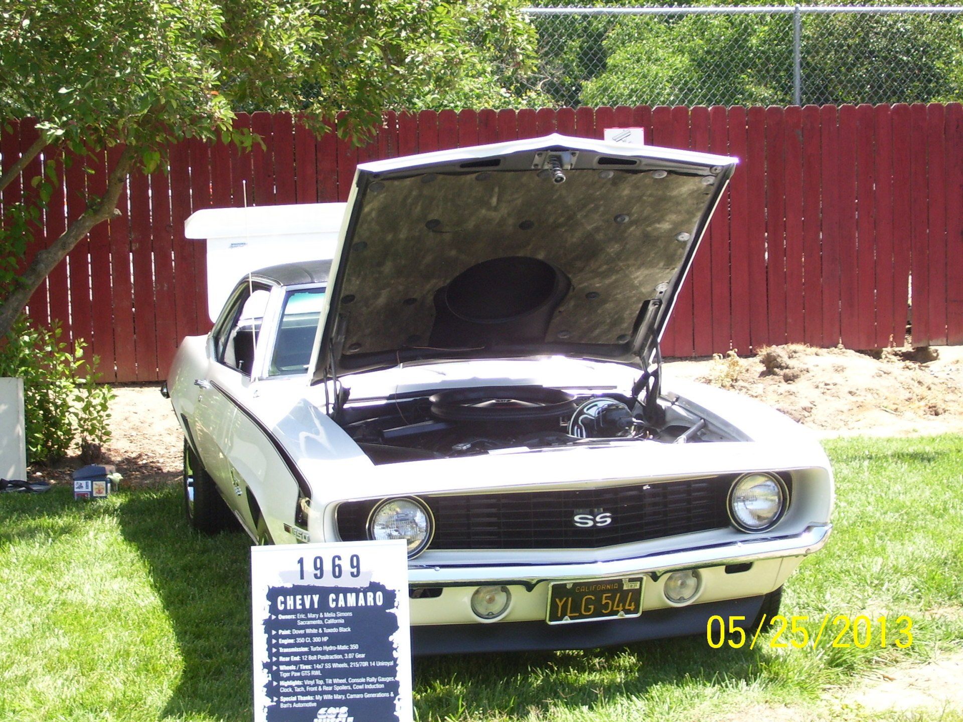 A white car with the hood up and a sign that says 1969