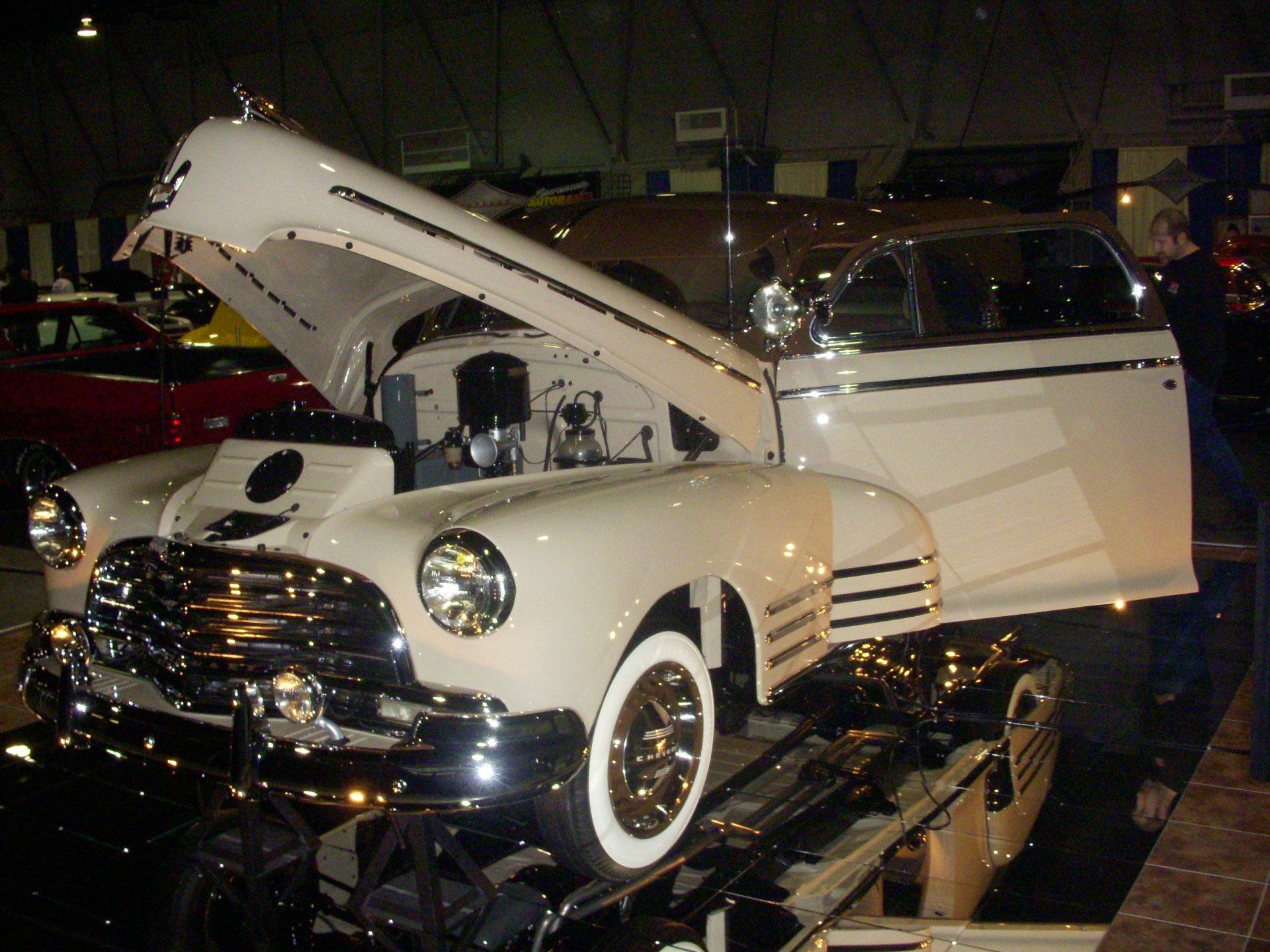 A white car with the hood up and the door open