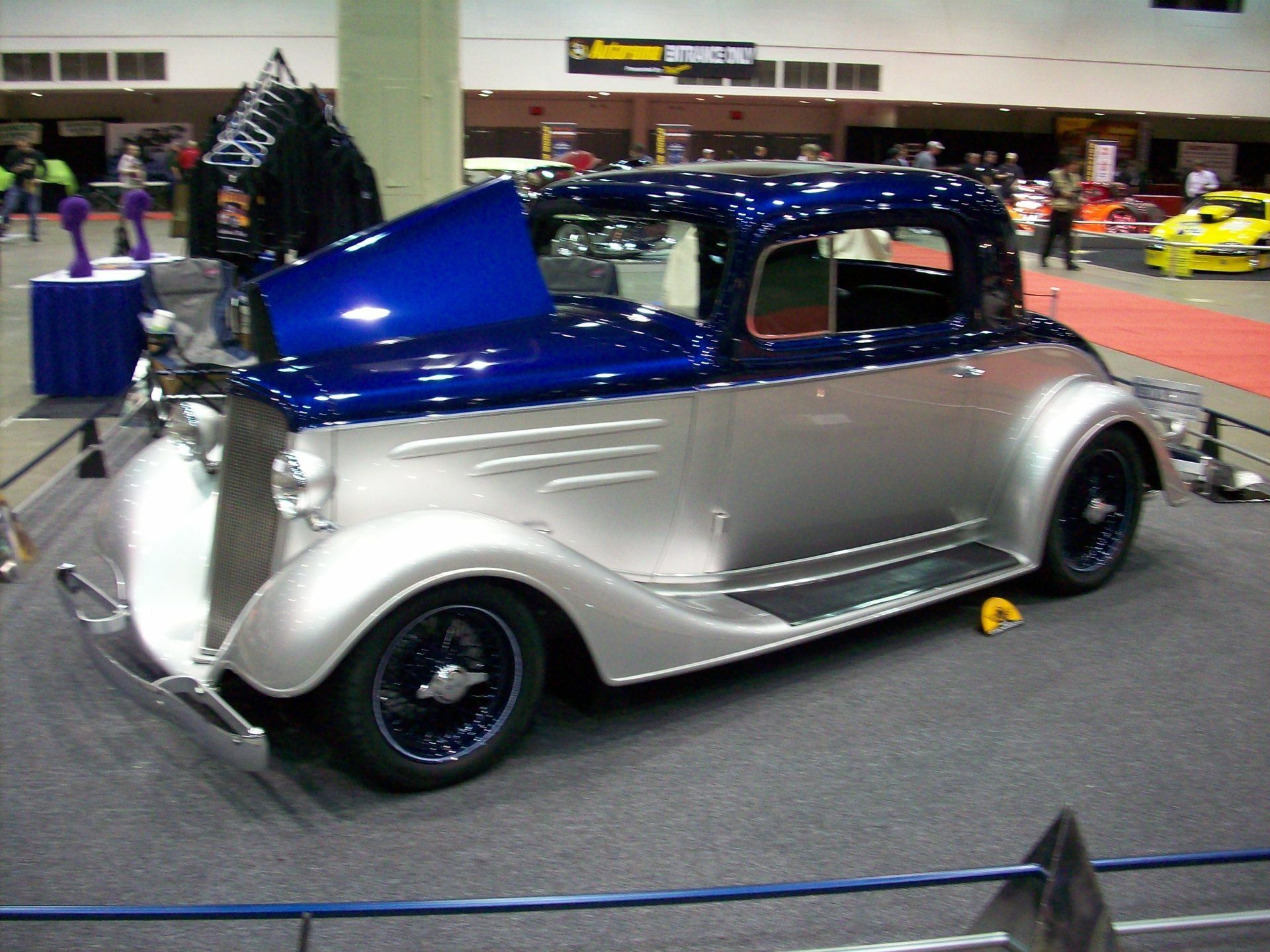 A silver and blue car with the hood up