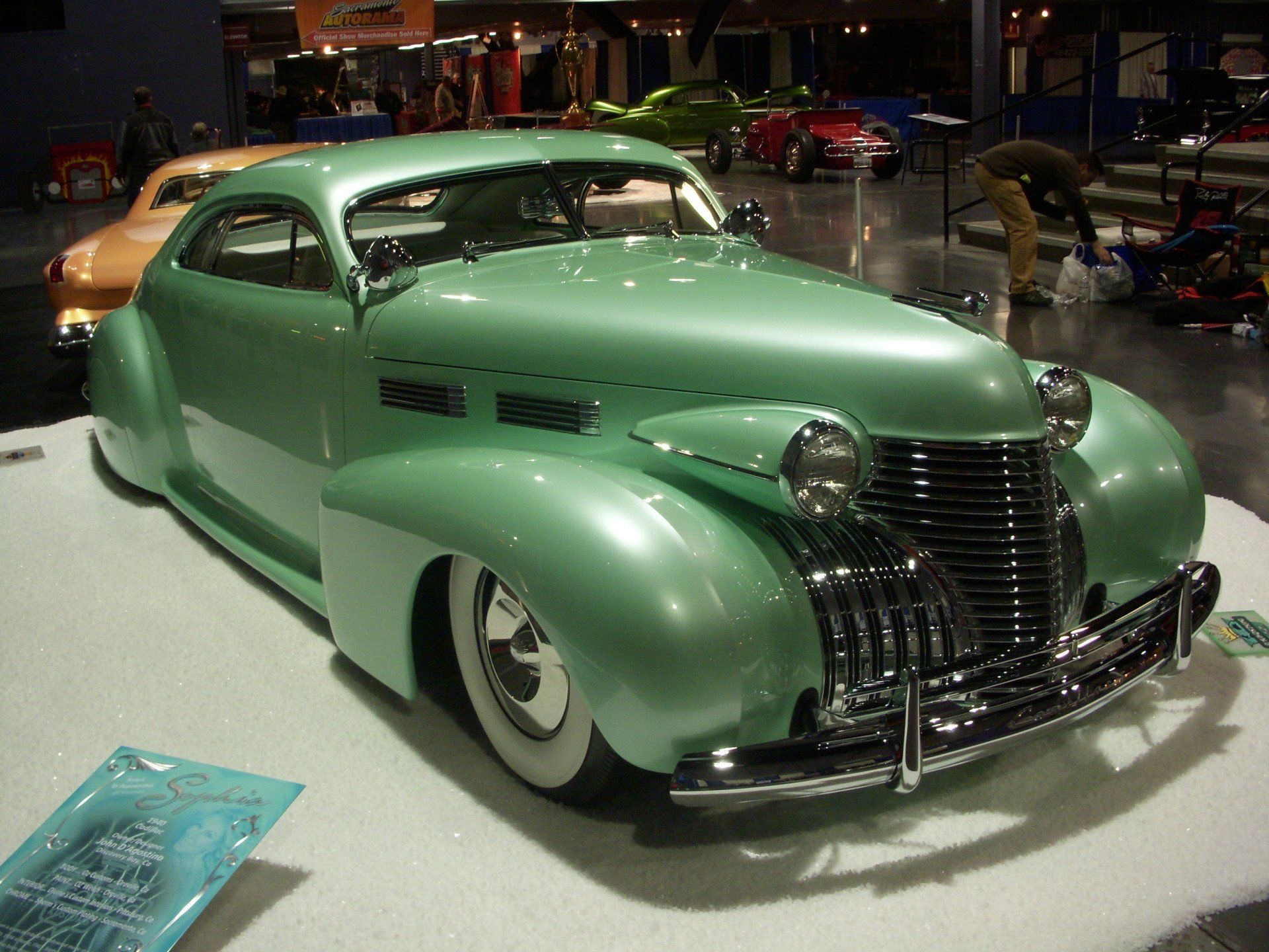 A green car is on display at a car show