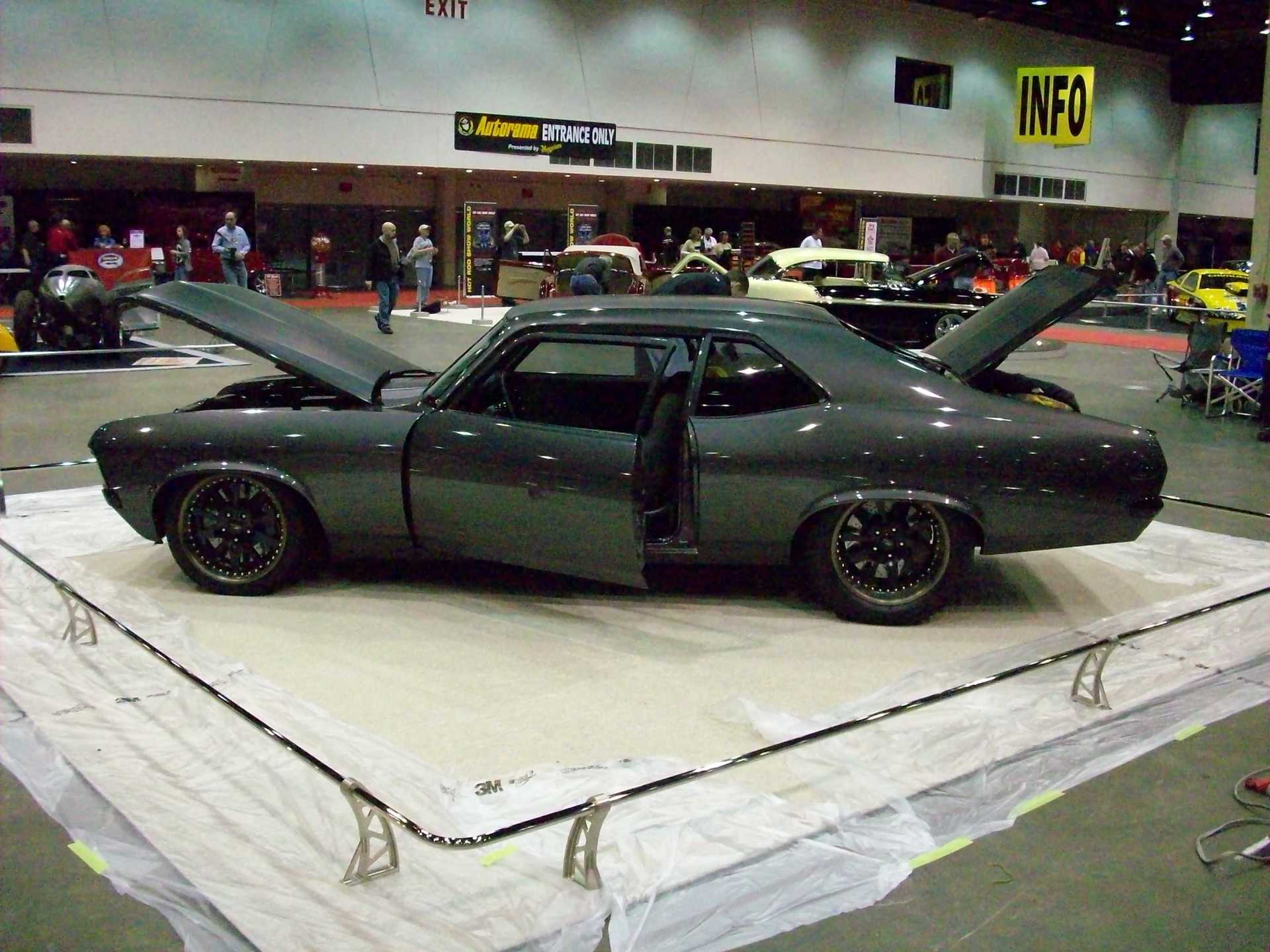 A car with the hood up is on display at a car show