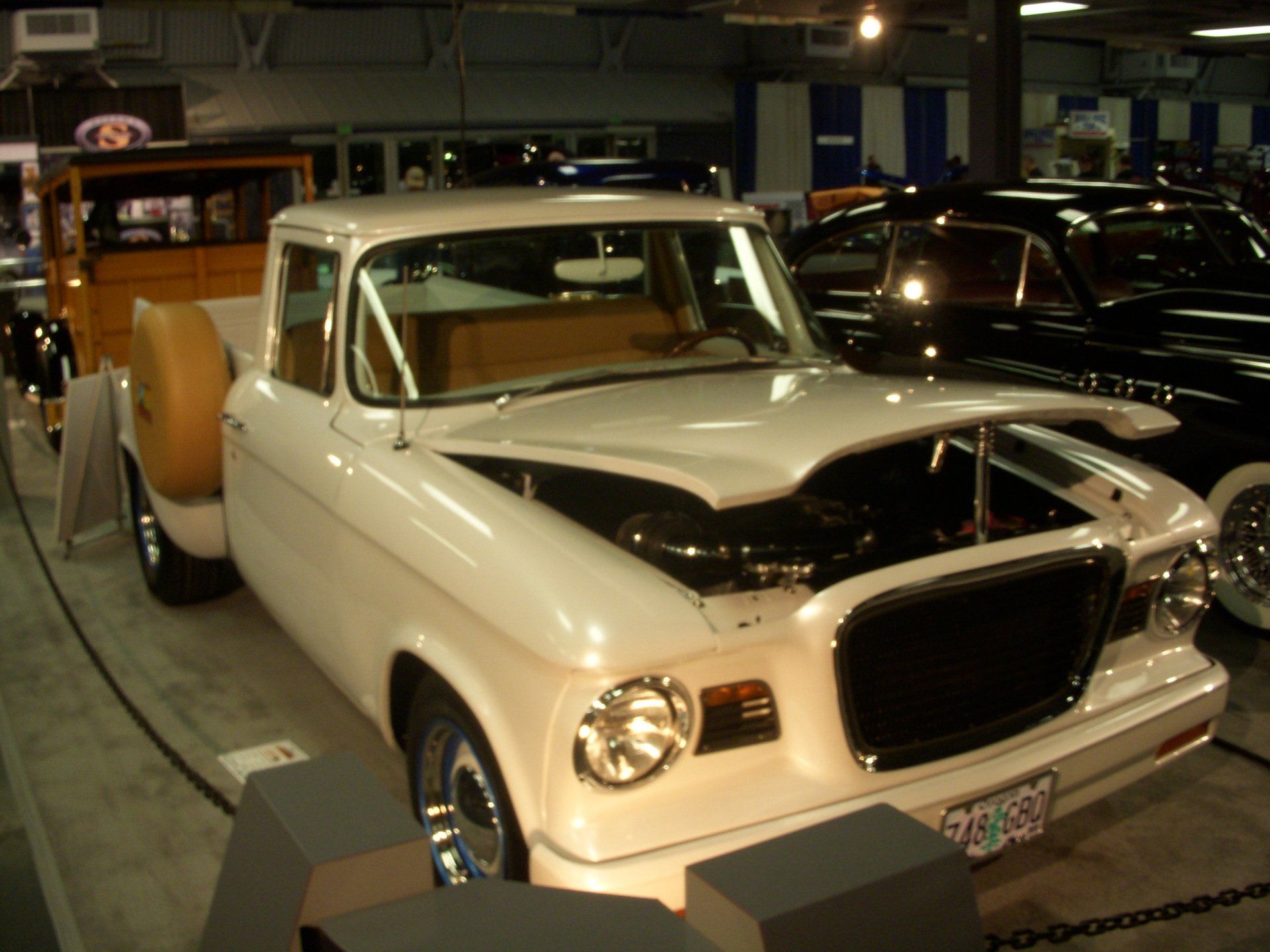 A white pickup truck with the hood up and a license plate that says ' tc ' on it