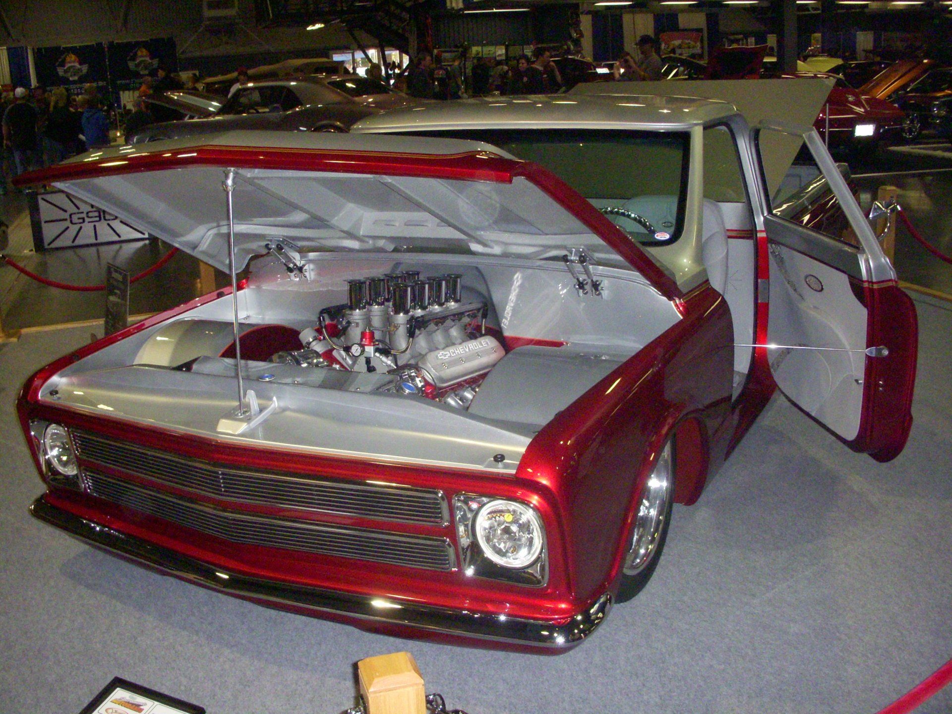 A red truck with the hood open and the doors open