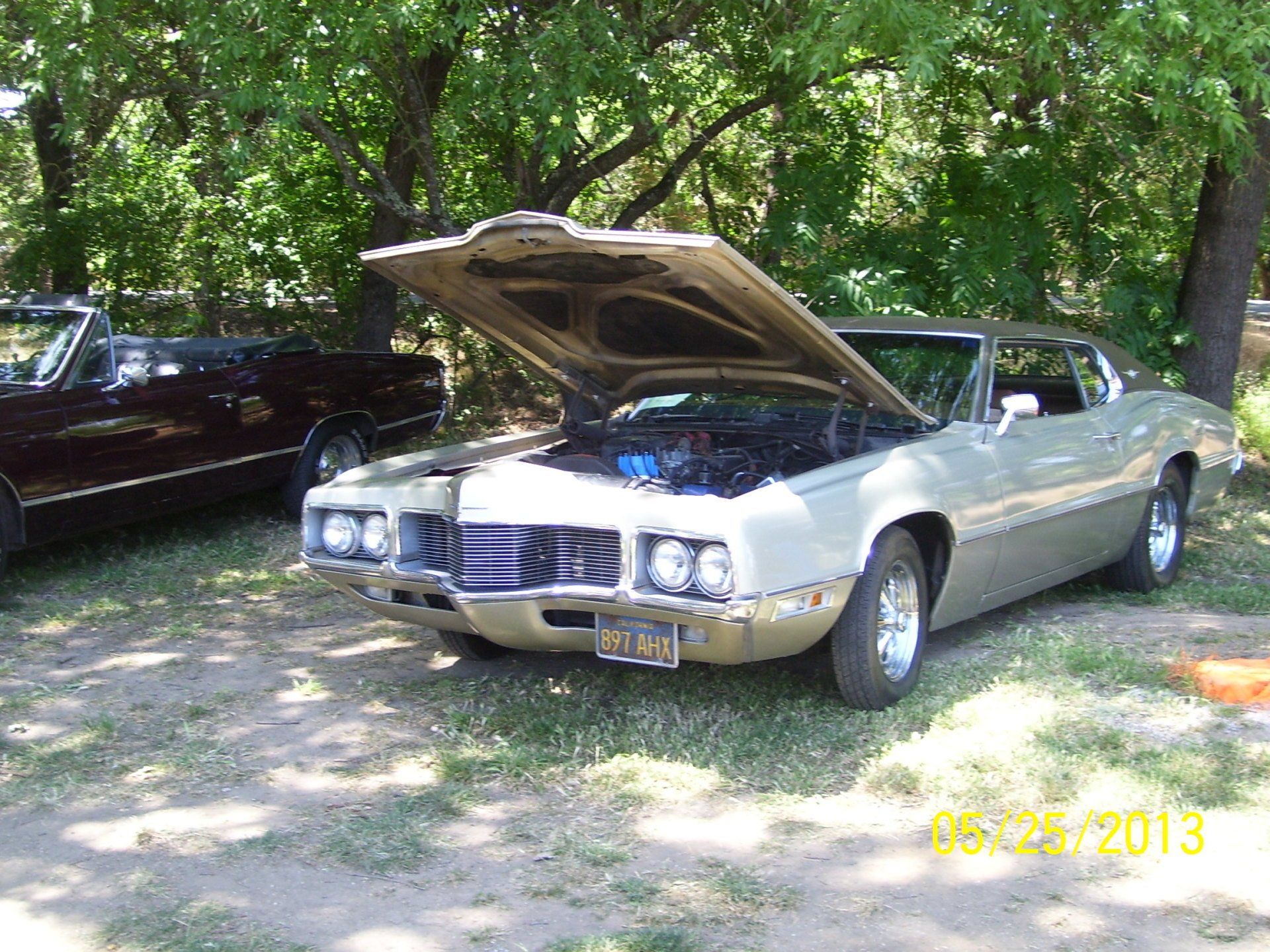 A car with the hood up is parked next to another car