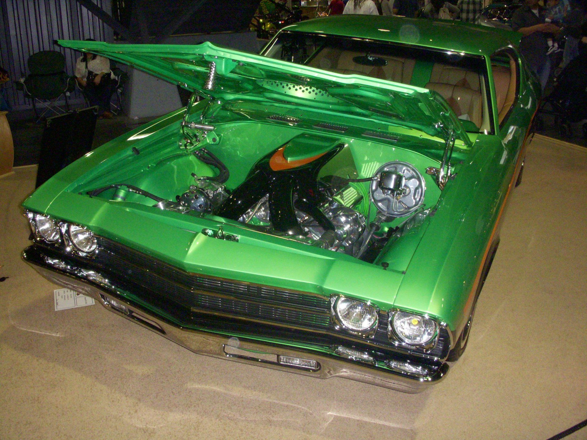 A green car with the hood open is on display
