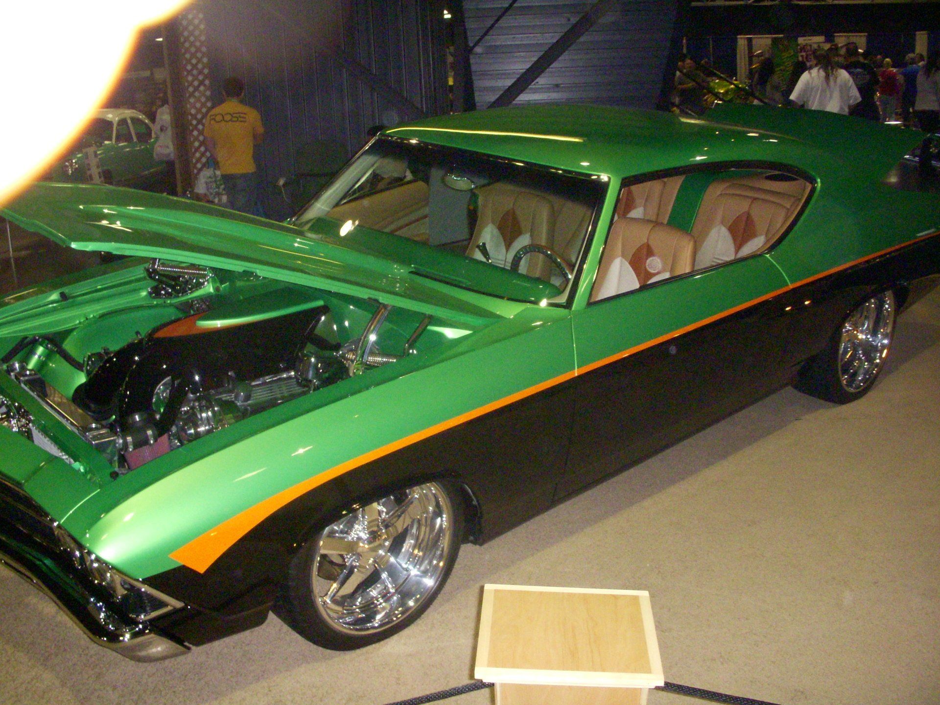A green and black car with the hood open