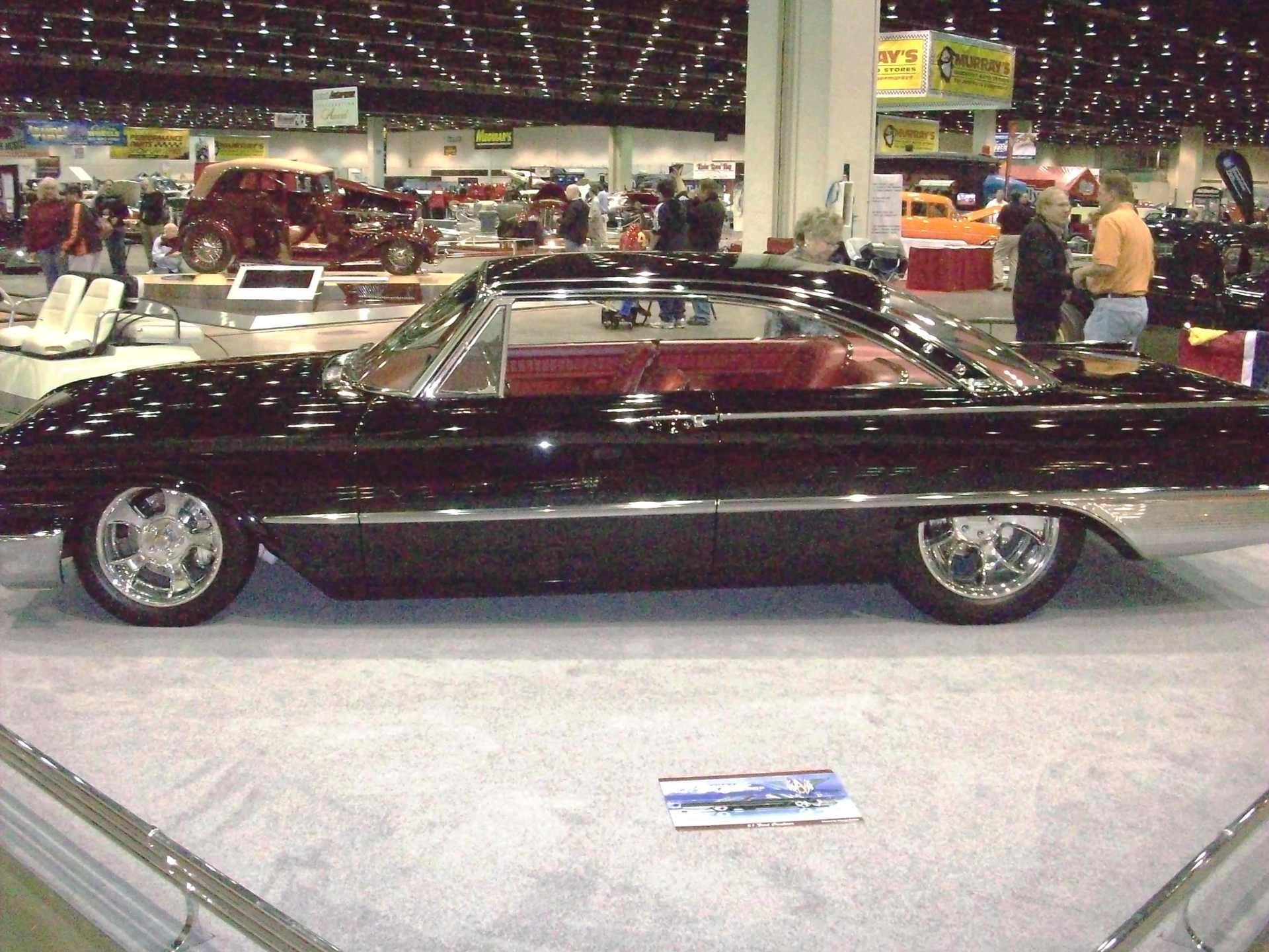 A black car is on display at a car show