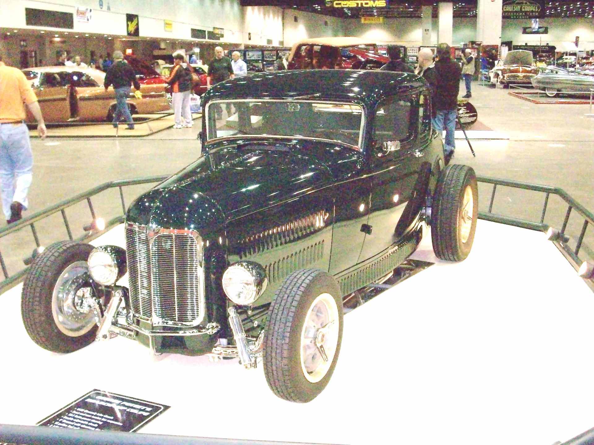 A black car is on display at a car show