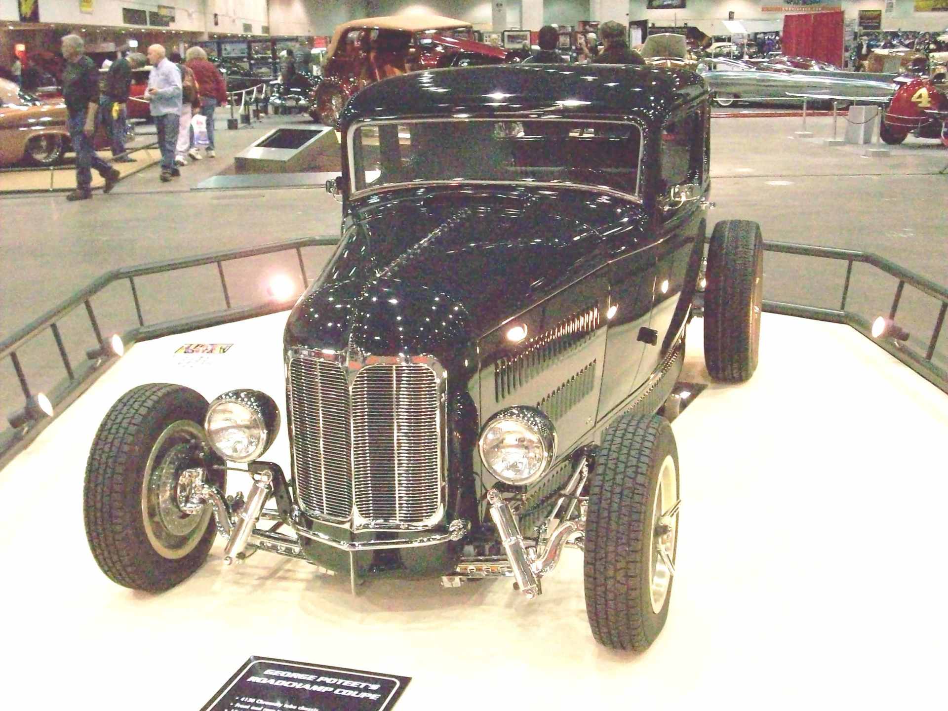 A black car is on display at a car show