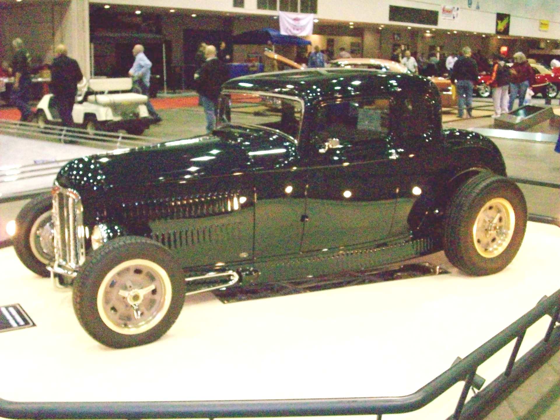 A black car is on display at a car show