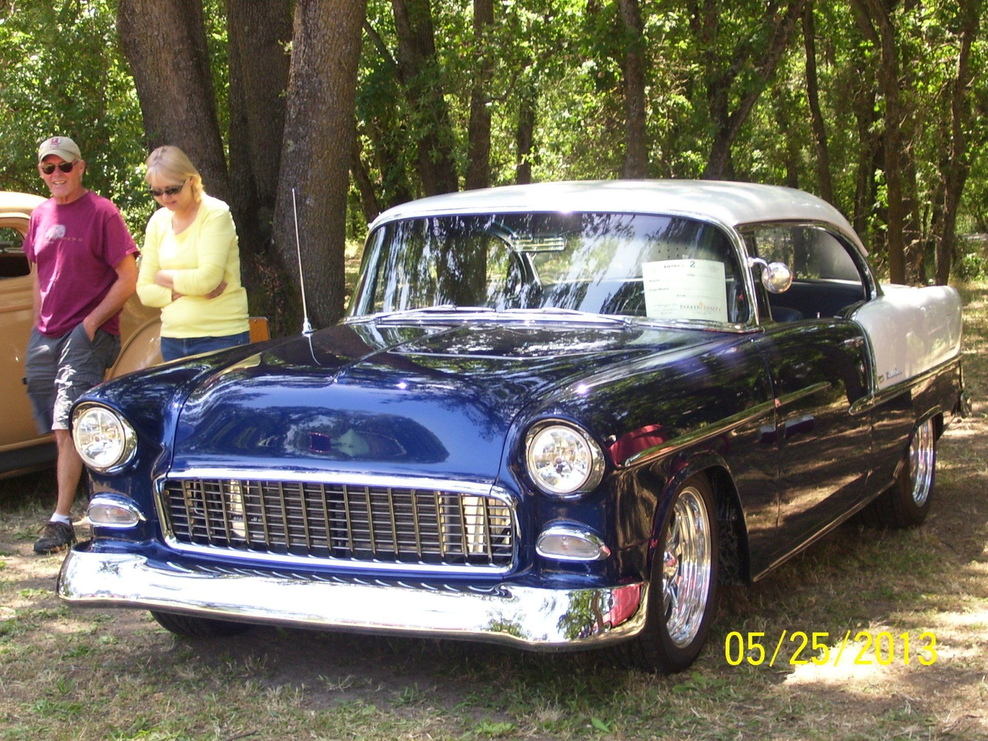 A black and white car is parked in the woods