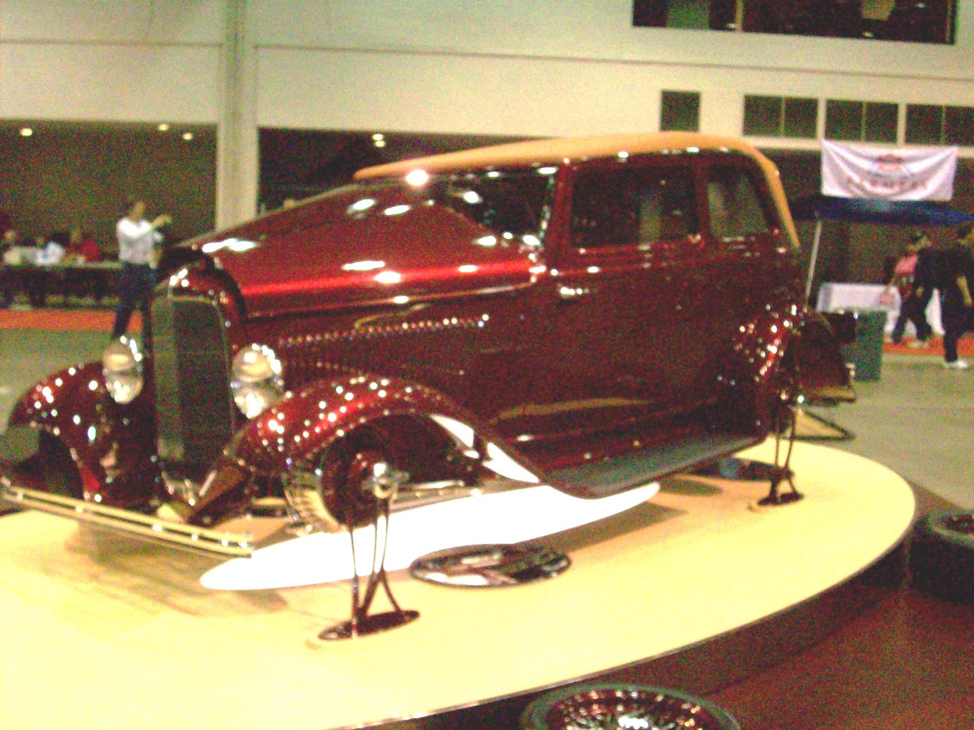 A red car is on display at a car show