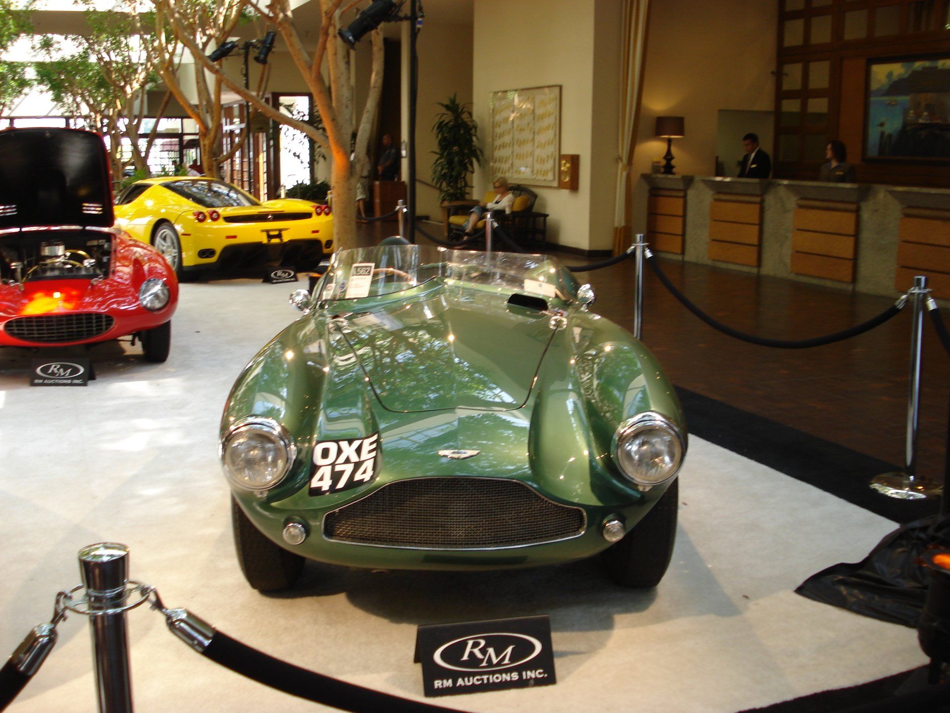 A green car with a license plate that says qxe 474