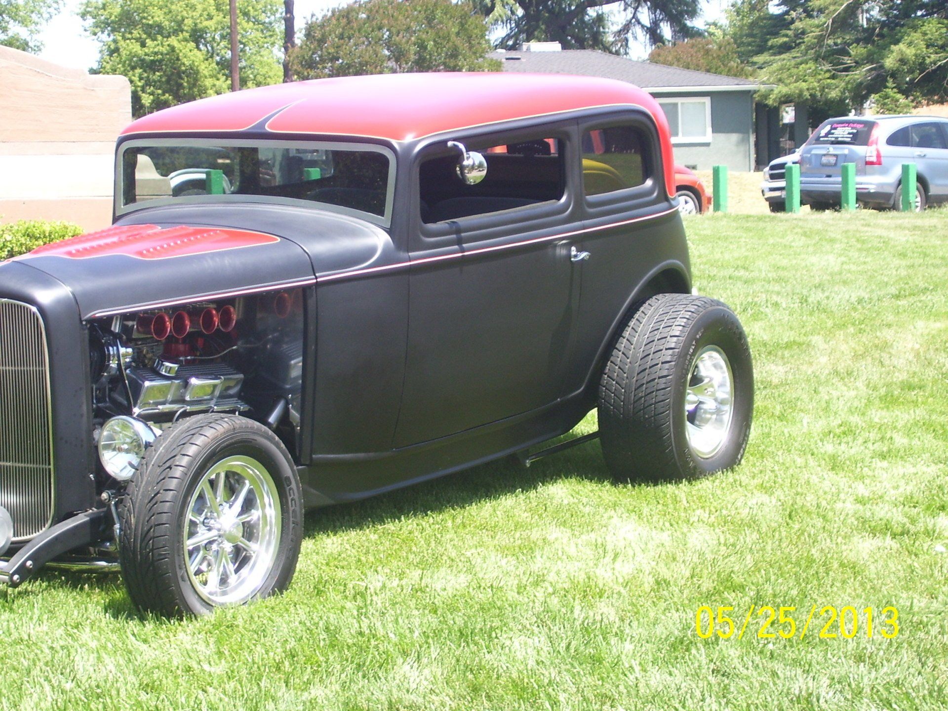 A black and red car is parked in the grass