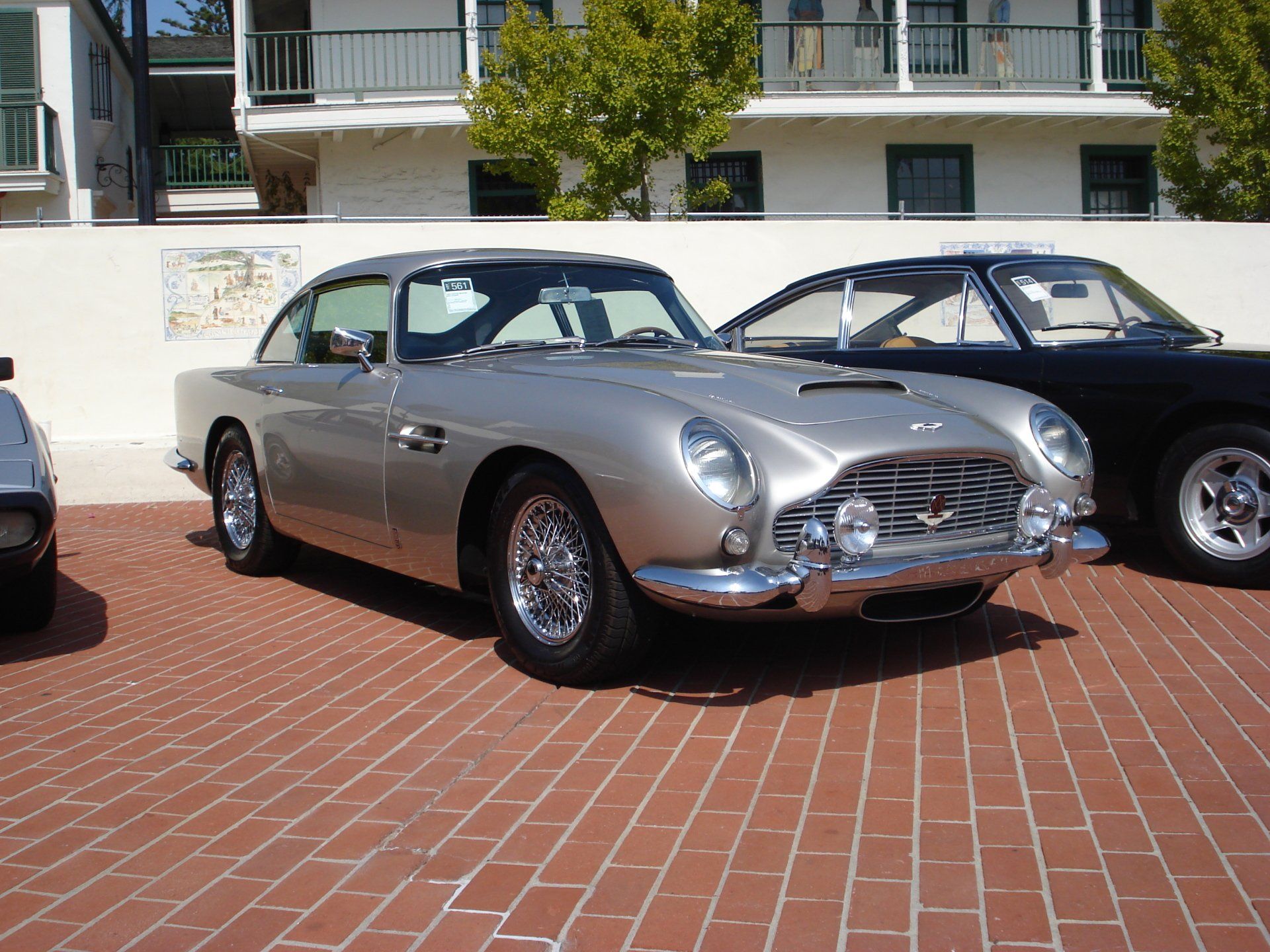 A silver car is parked next to a black car