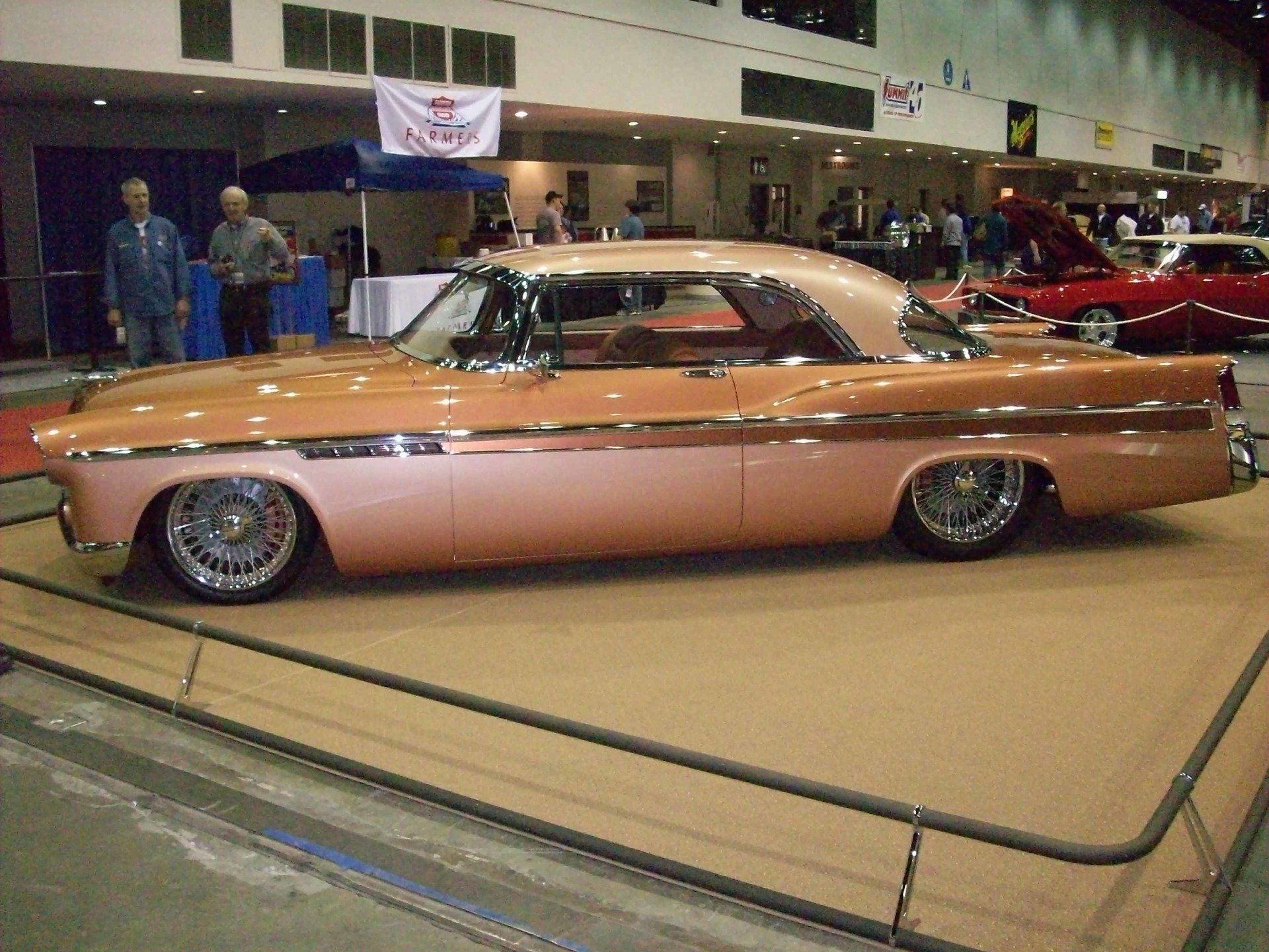 A pink car is on display at a car show