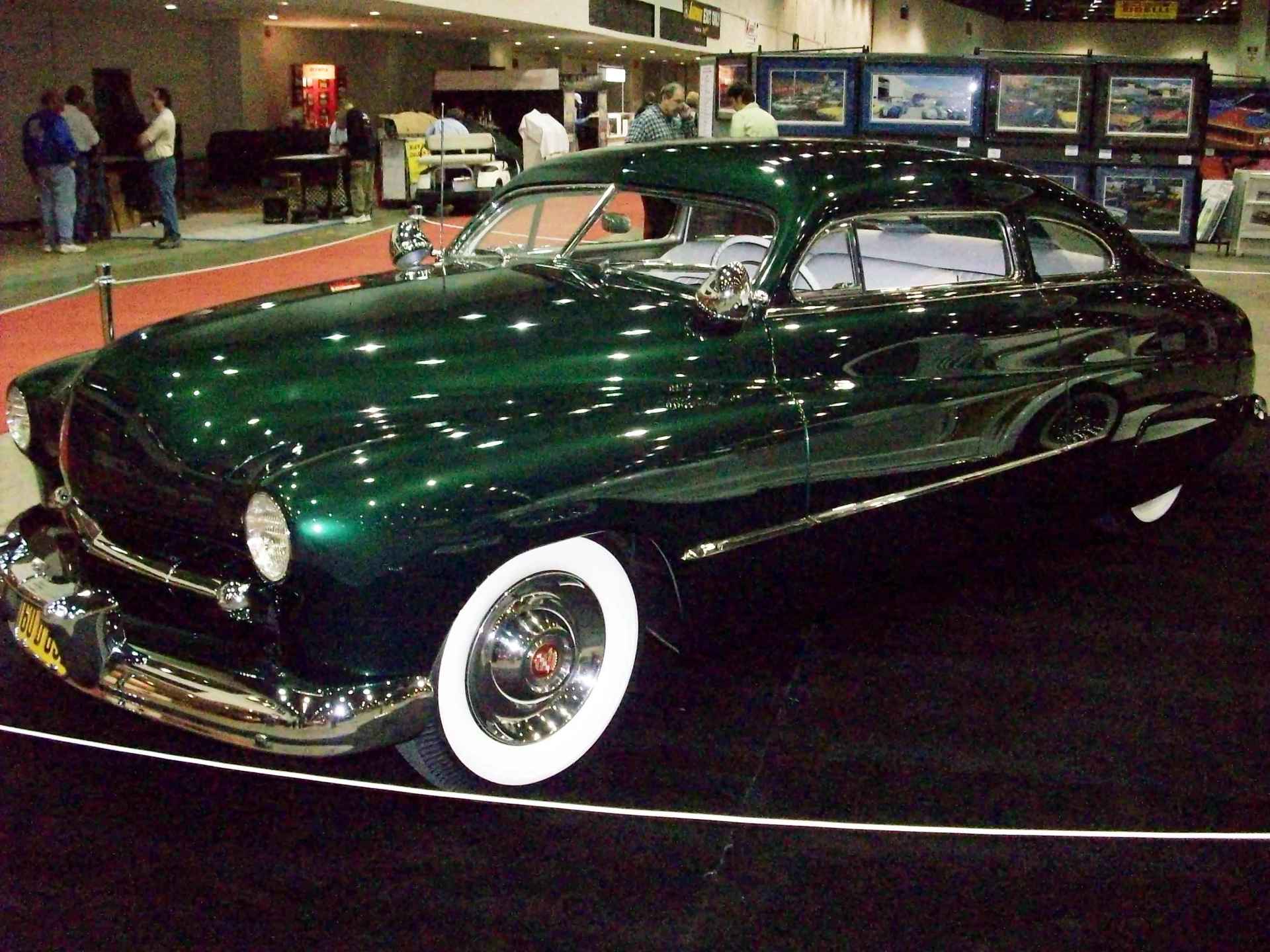 A green car with white tires is on display