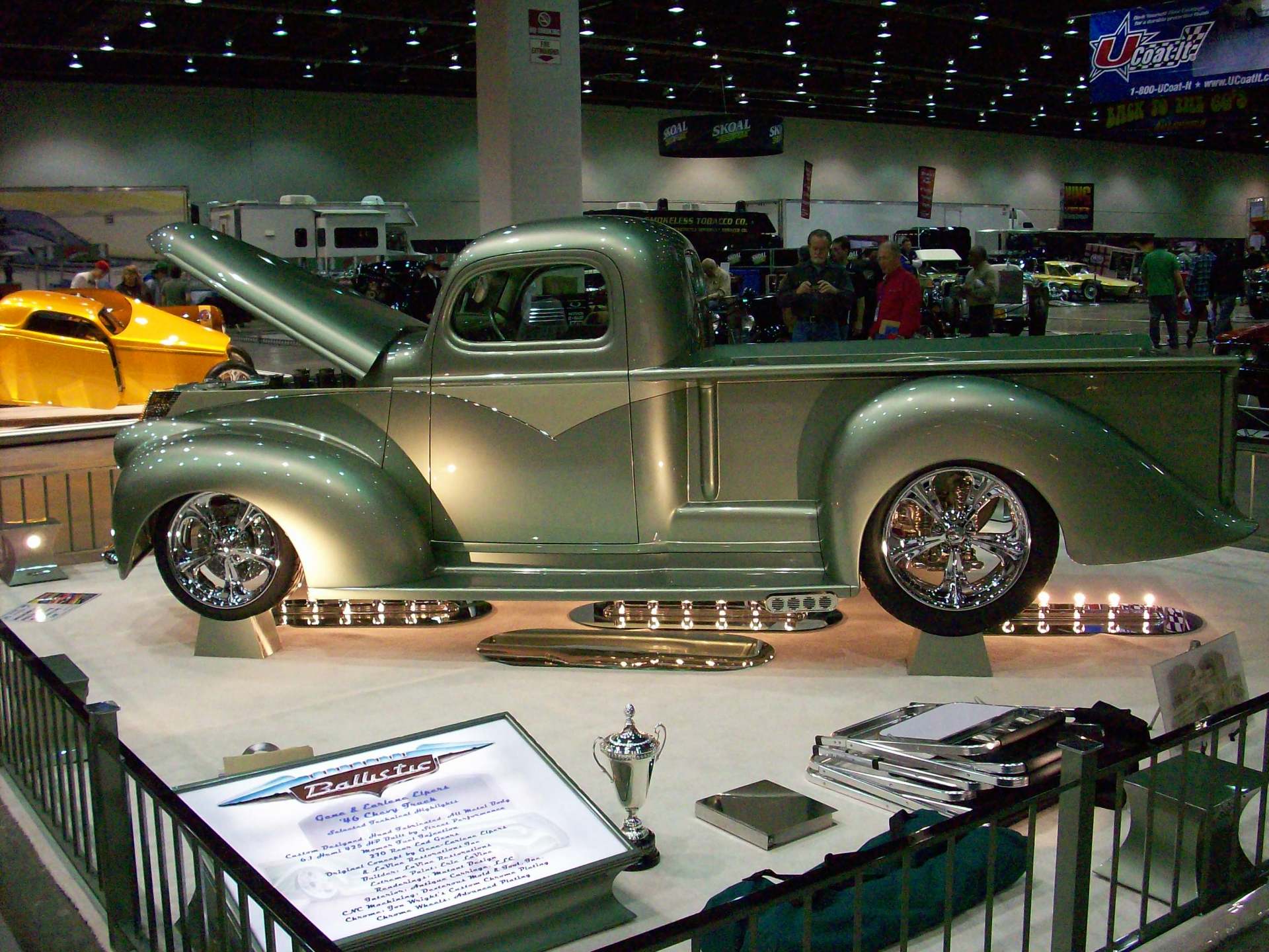 A silver truck is on display at a car show