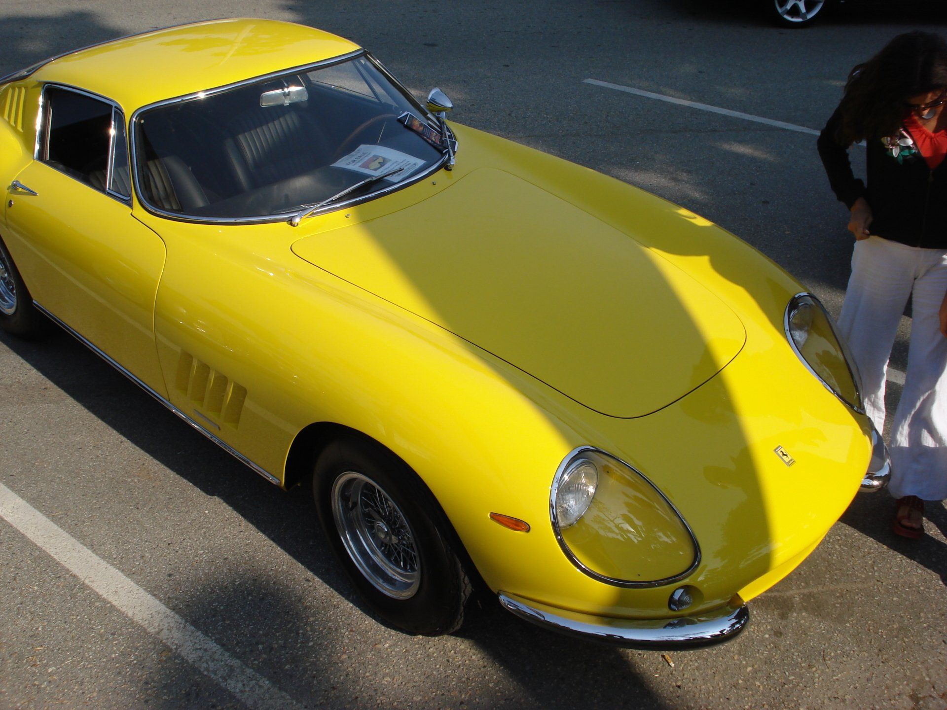 A yellow sports car is parked in a parking lot