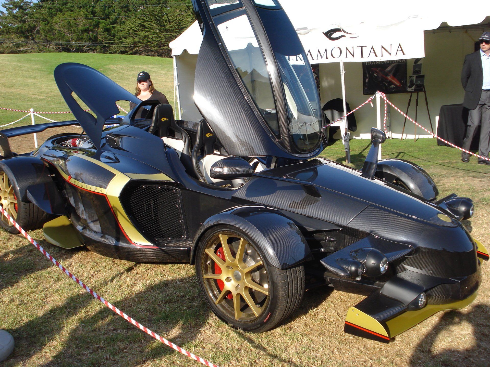 A three wheeled car is parked in front of a montana tent
