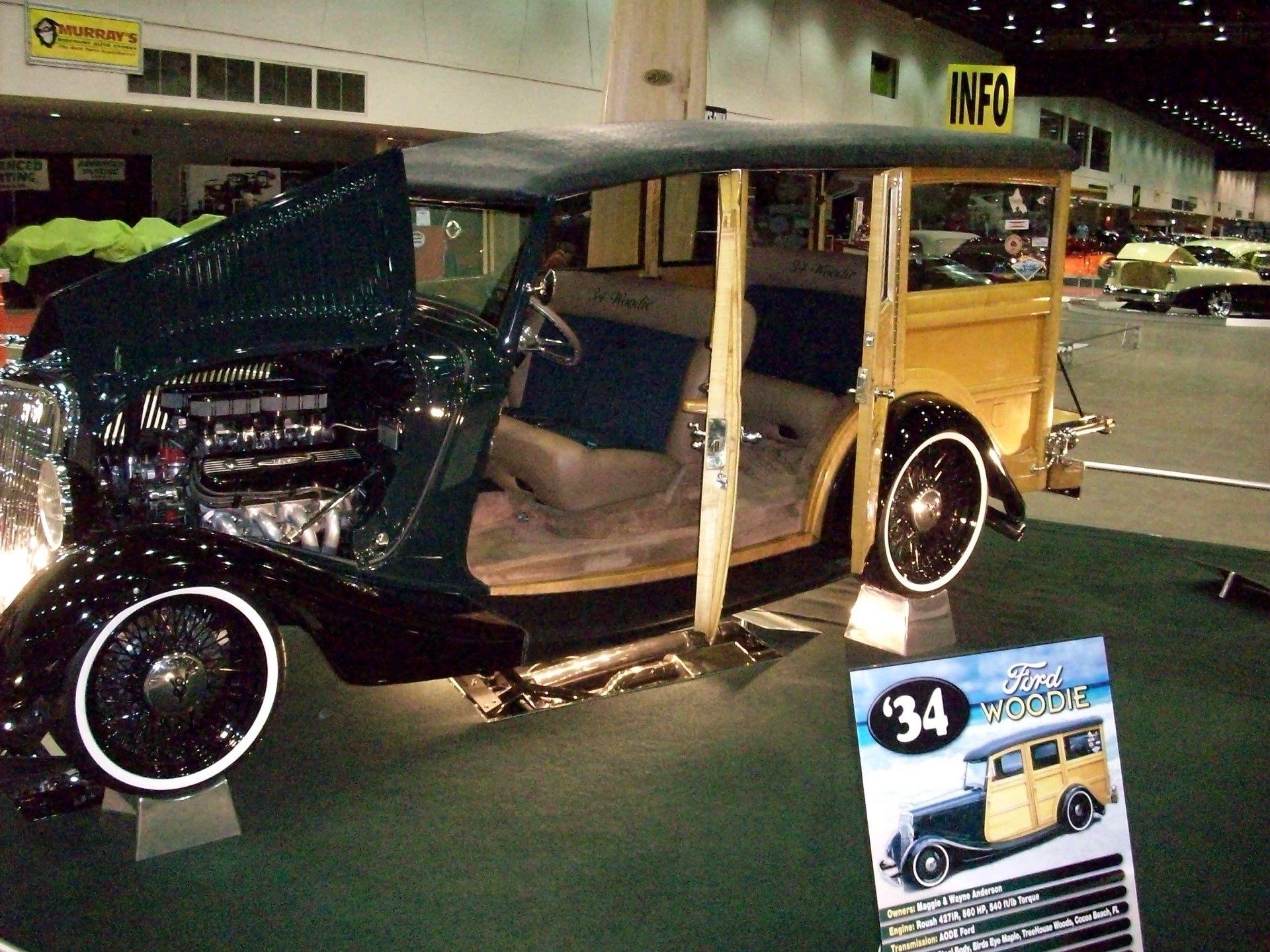A car with the hood open is on display at a car show