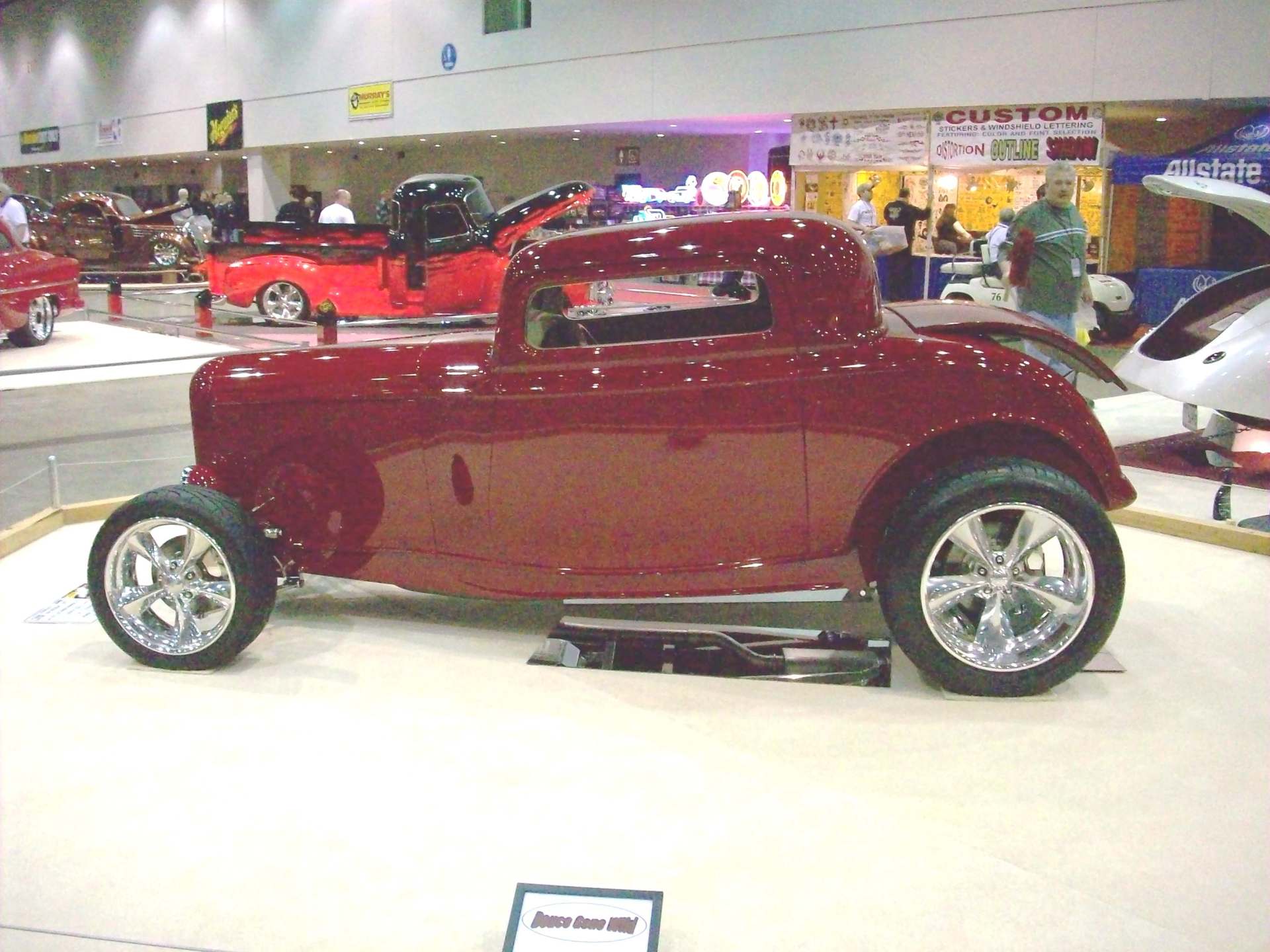 A red car is on display at a car show