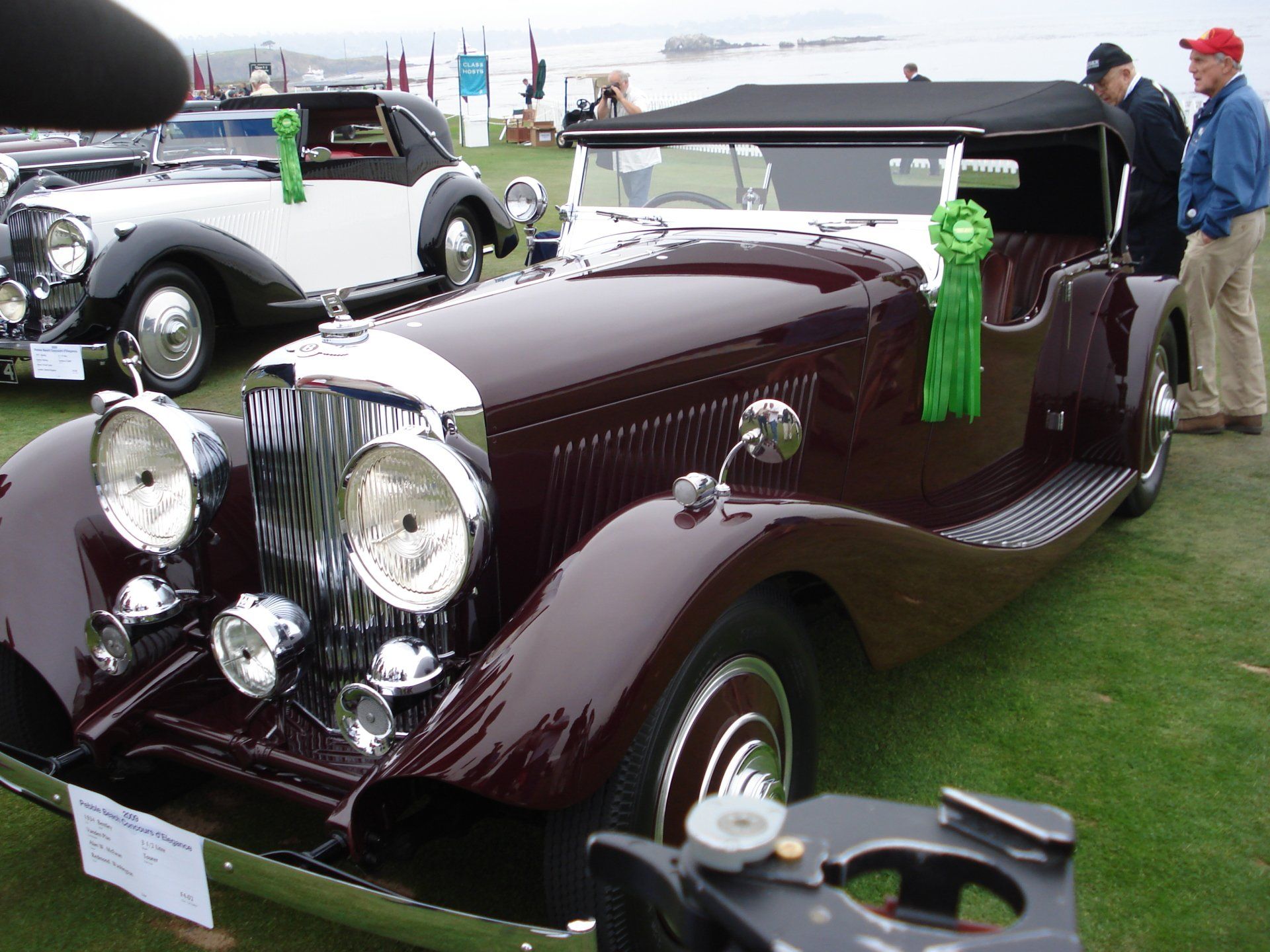 A car with a green ribbon on it is on display at a car show