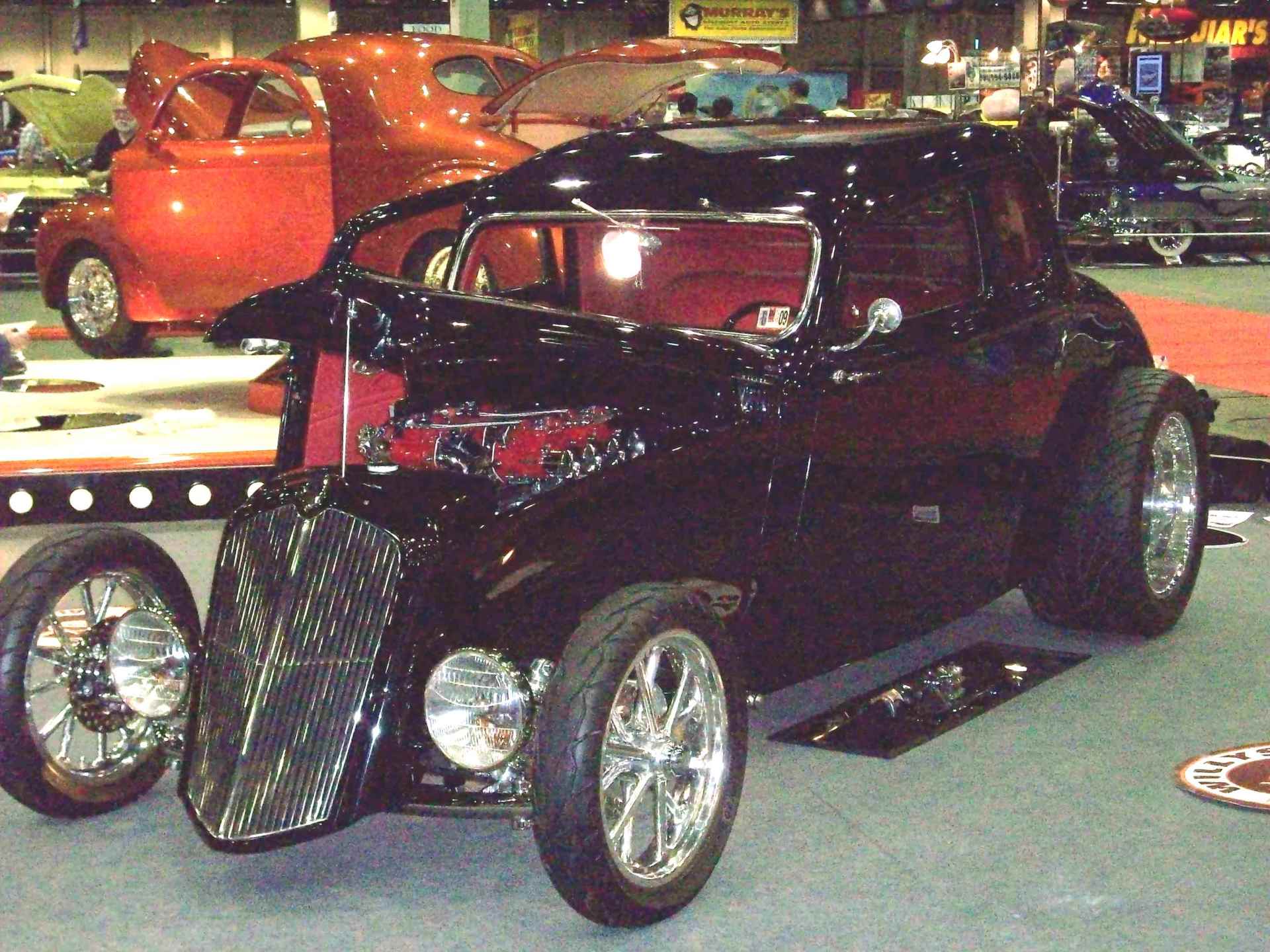 A black car is on display at a car show
