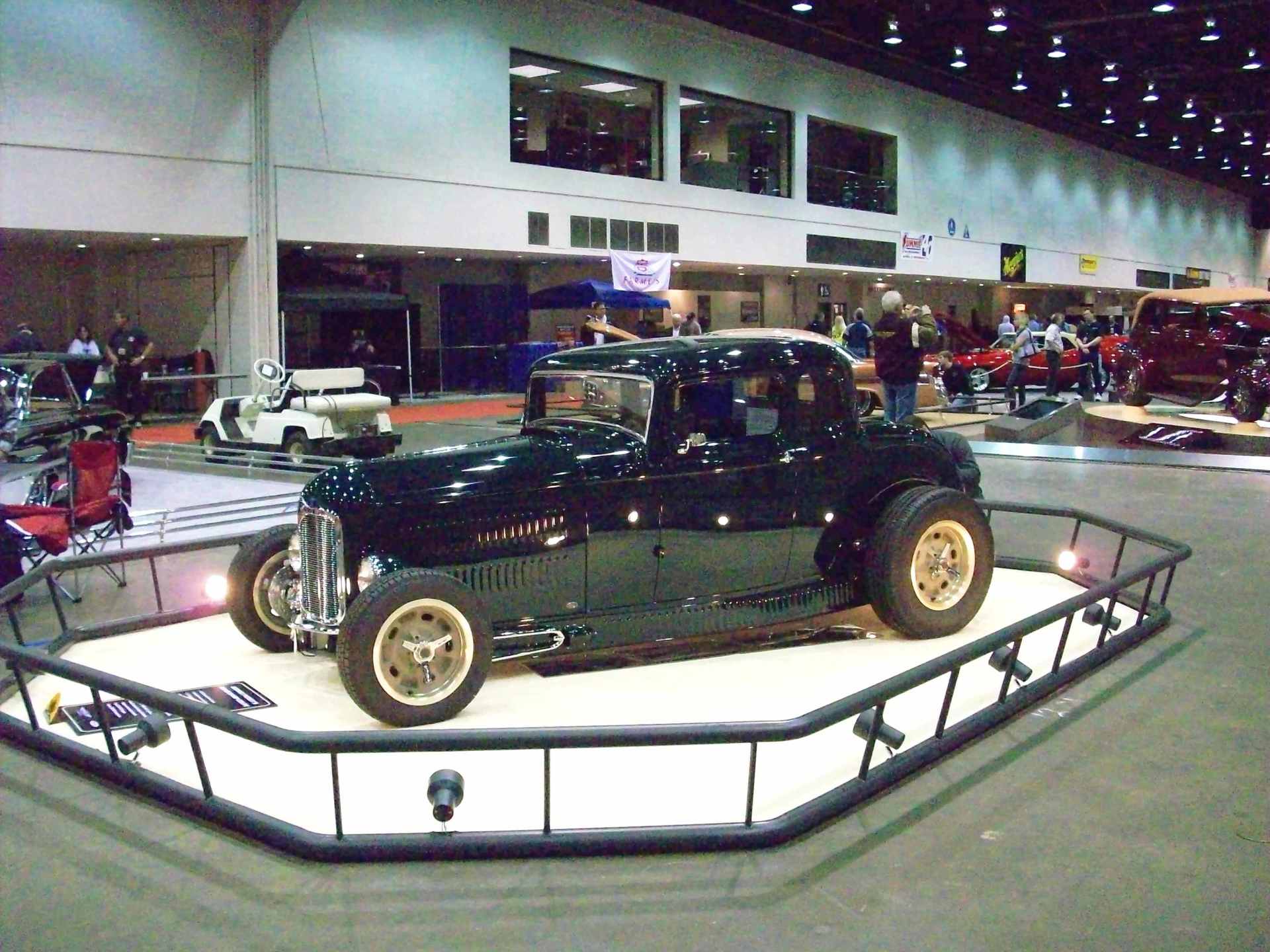 A black car is on display in a building