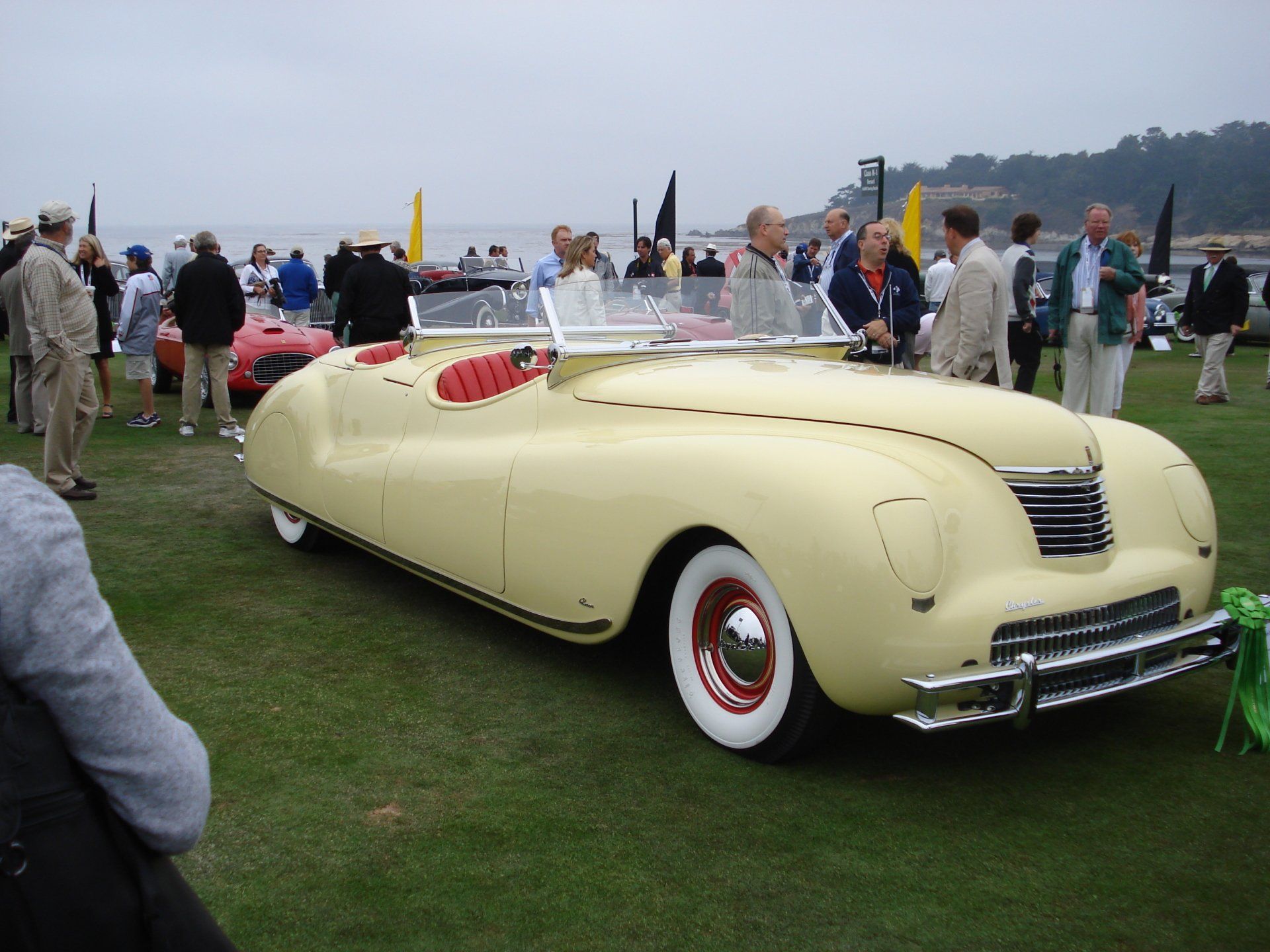 A group of people are gathered around a yellow car