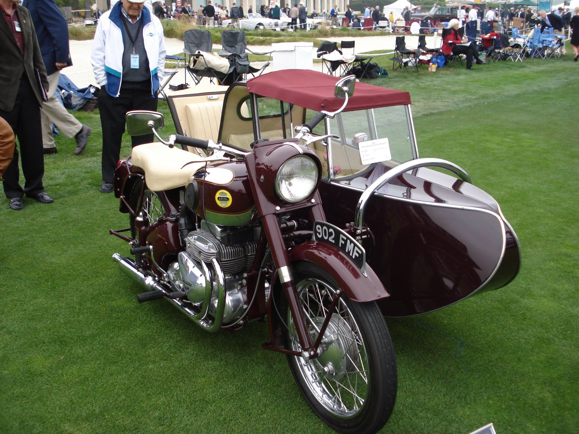 A motorcycle with a sidecar is parked on the grass