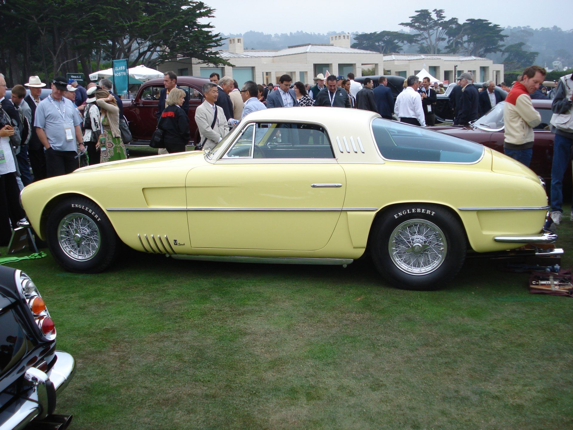A yellow car is parked in a grassy field