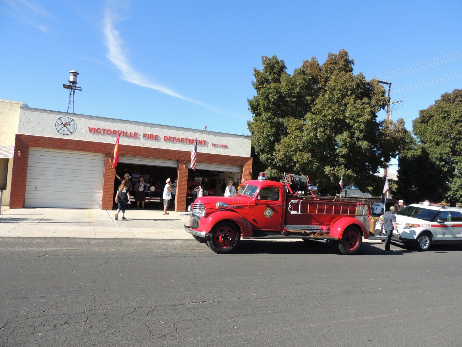A red fire truck is parked in front of a fire station