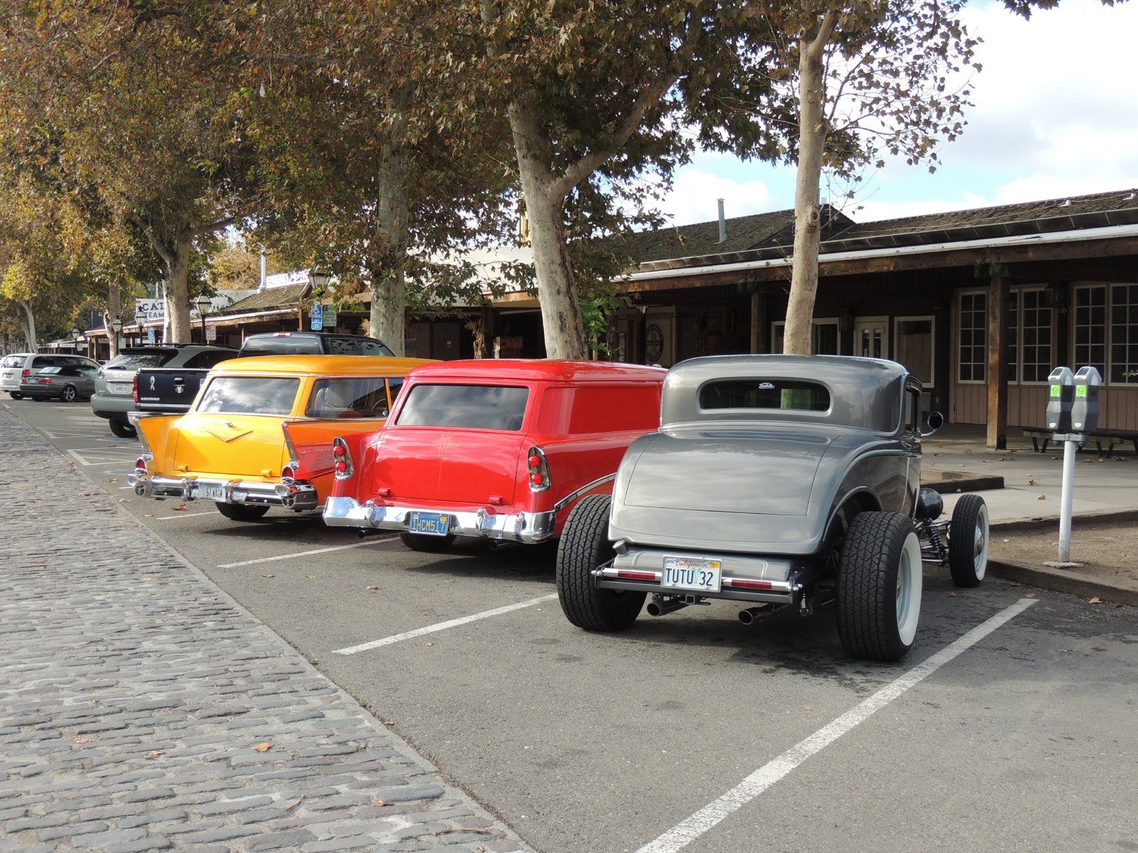 A row of old cars are parked in a parking lot