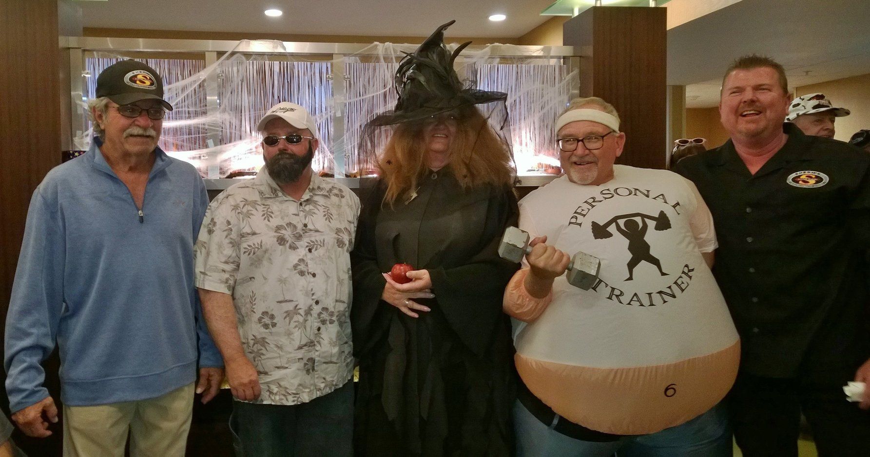 A group of people are posing for a picture and one of them is wearing a shirt with the number 6 on it