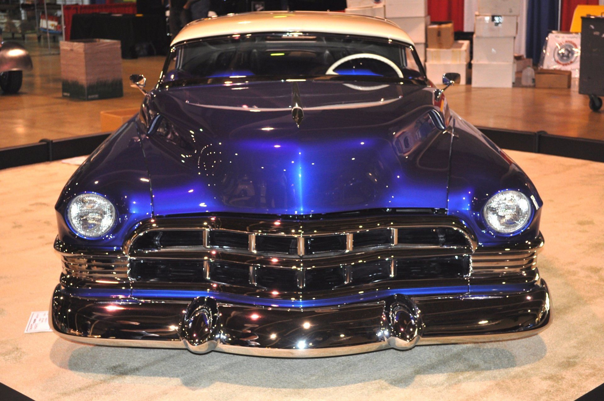 A blue car with a white top is on display