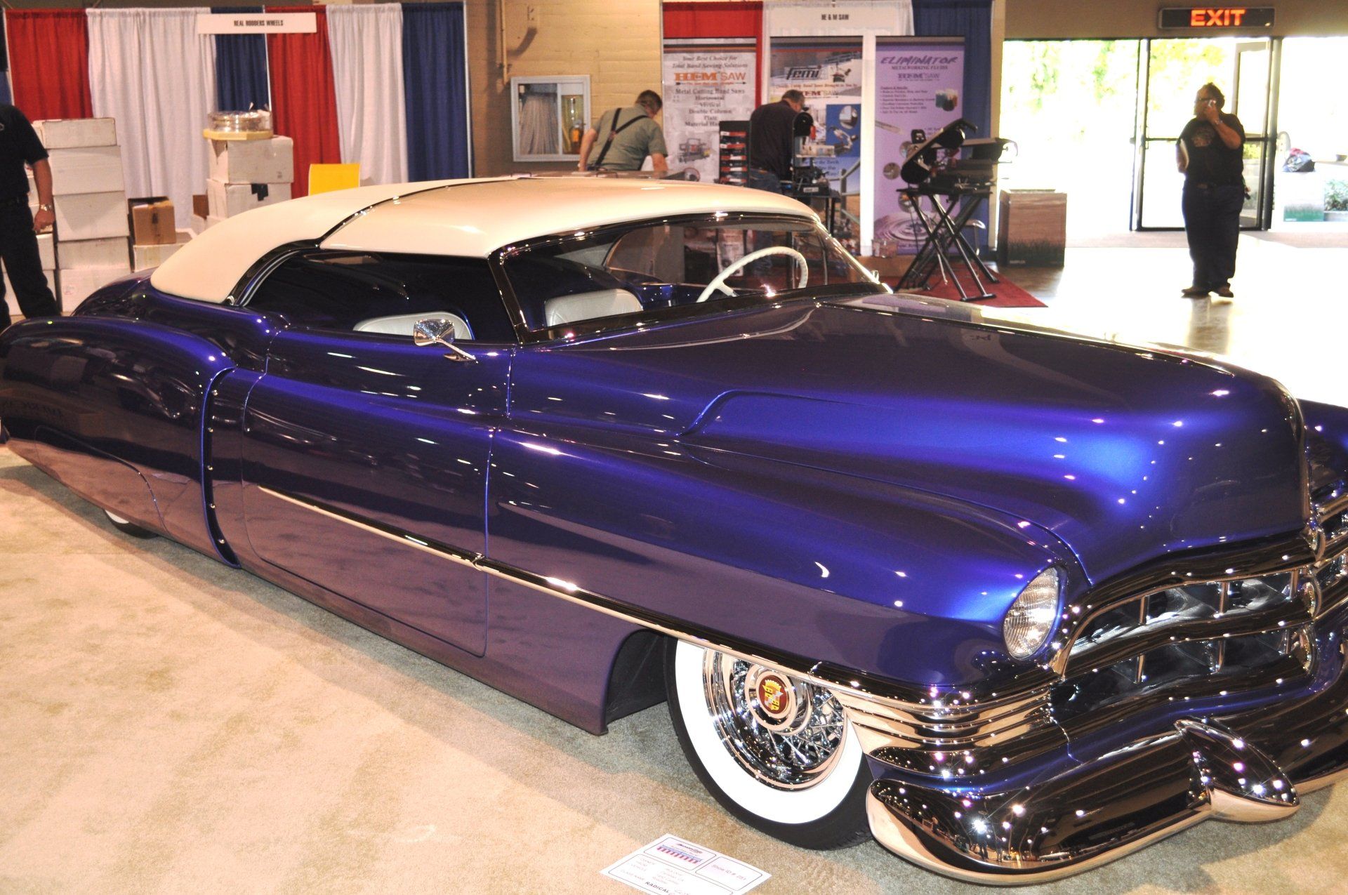 A purple car with a white top is on display