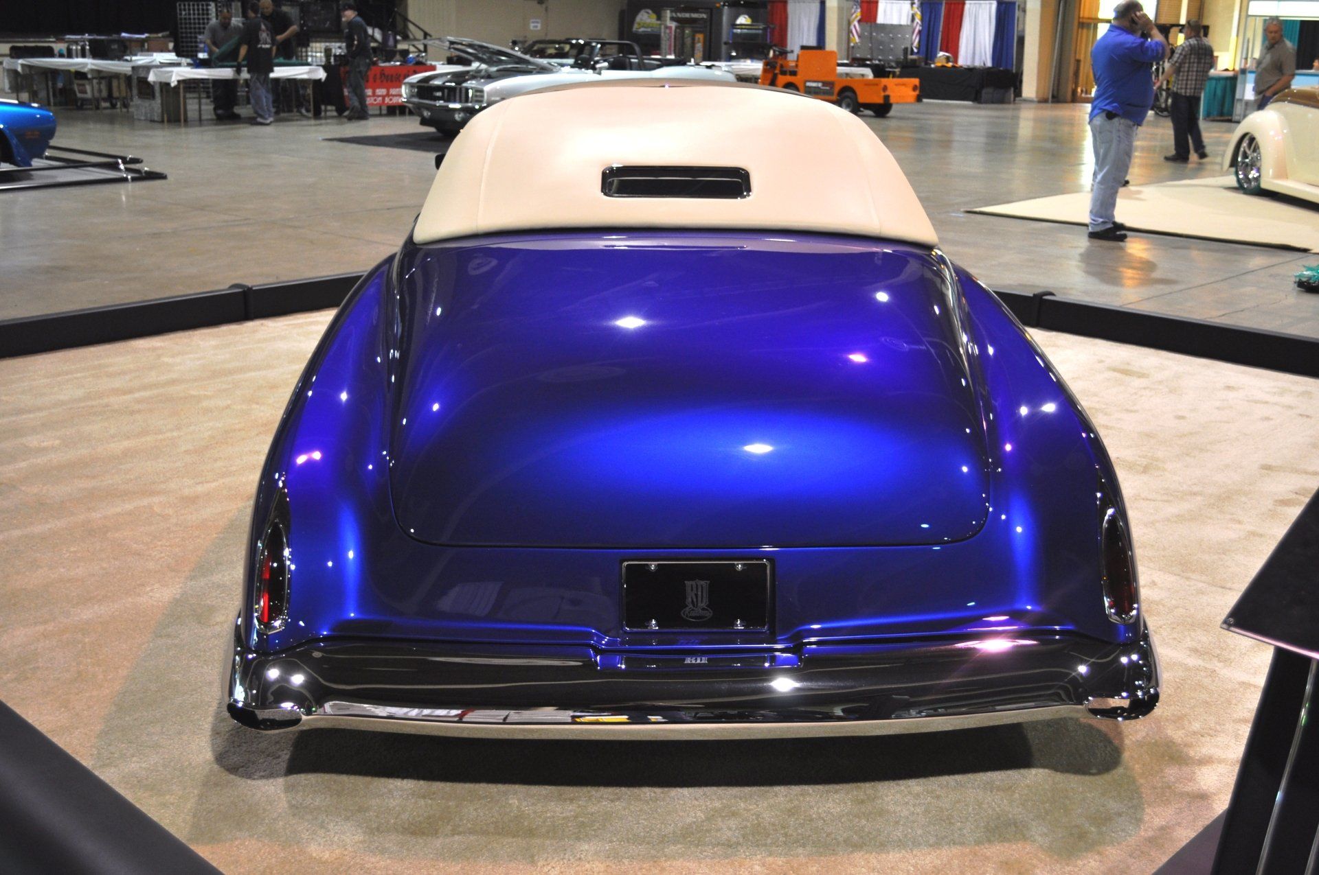 A blue car with a white top is on display