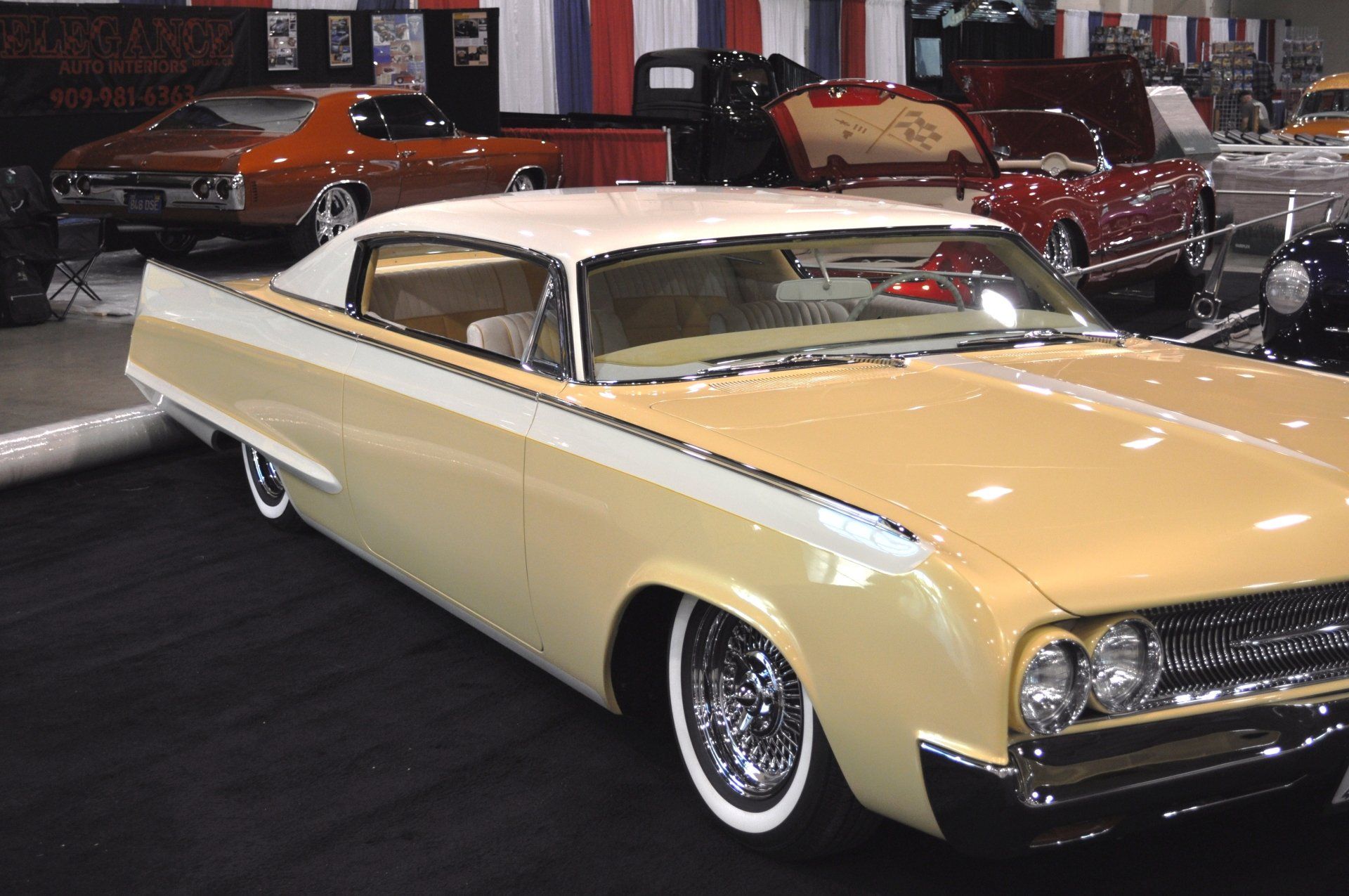A yellow and white car with white tires is on display